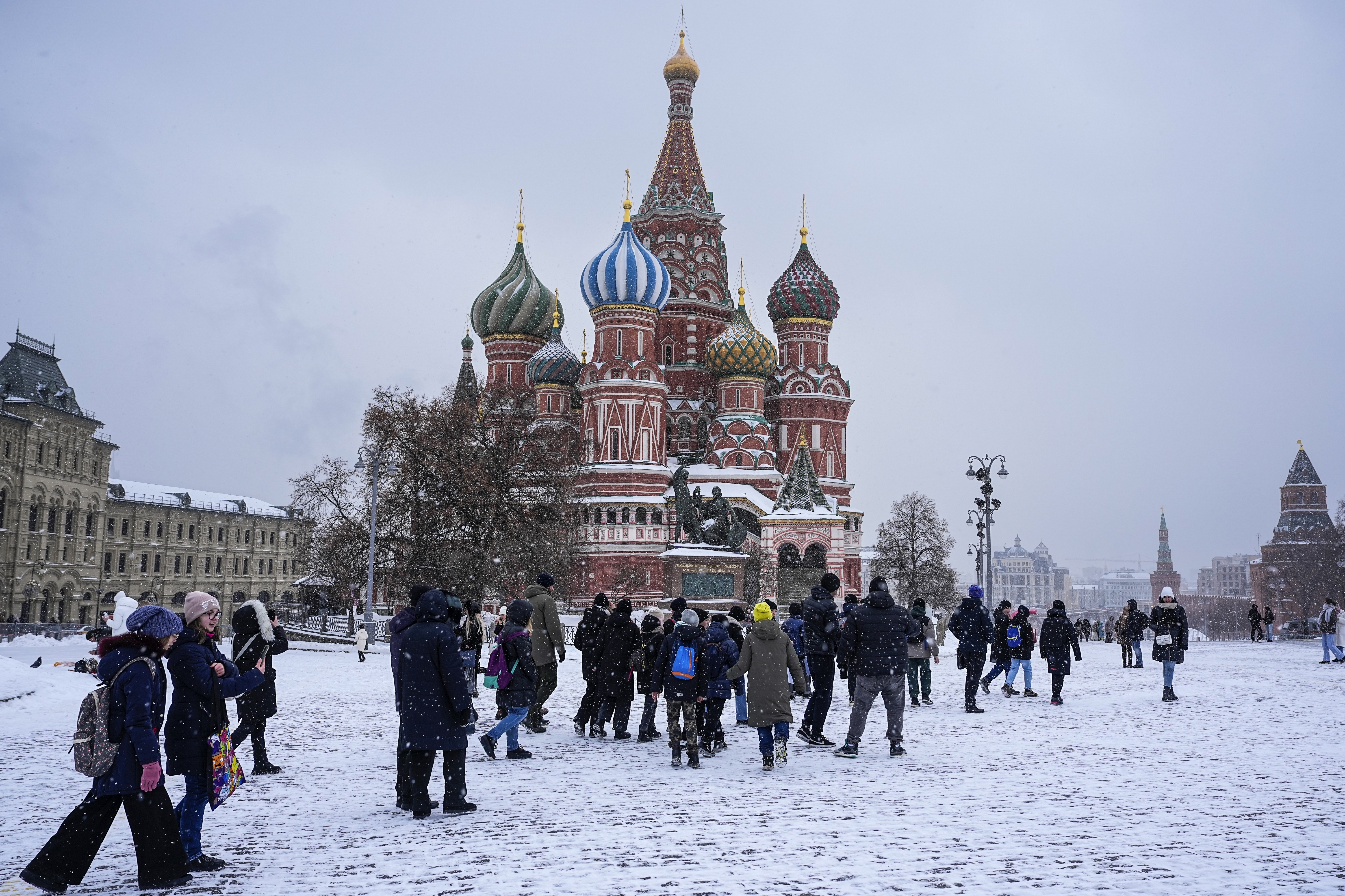 People walk through snow covered Red Square and St. Basil's Cathedral in Moscow, Russia, Tuesday, Nov. 28, 2023. (AP Photo/Alexander Zemlianichenko)