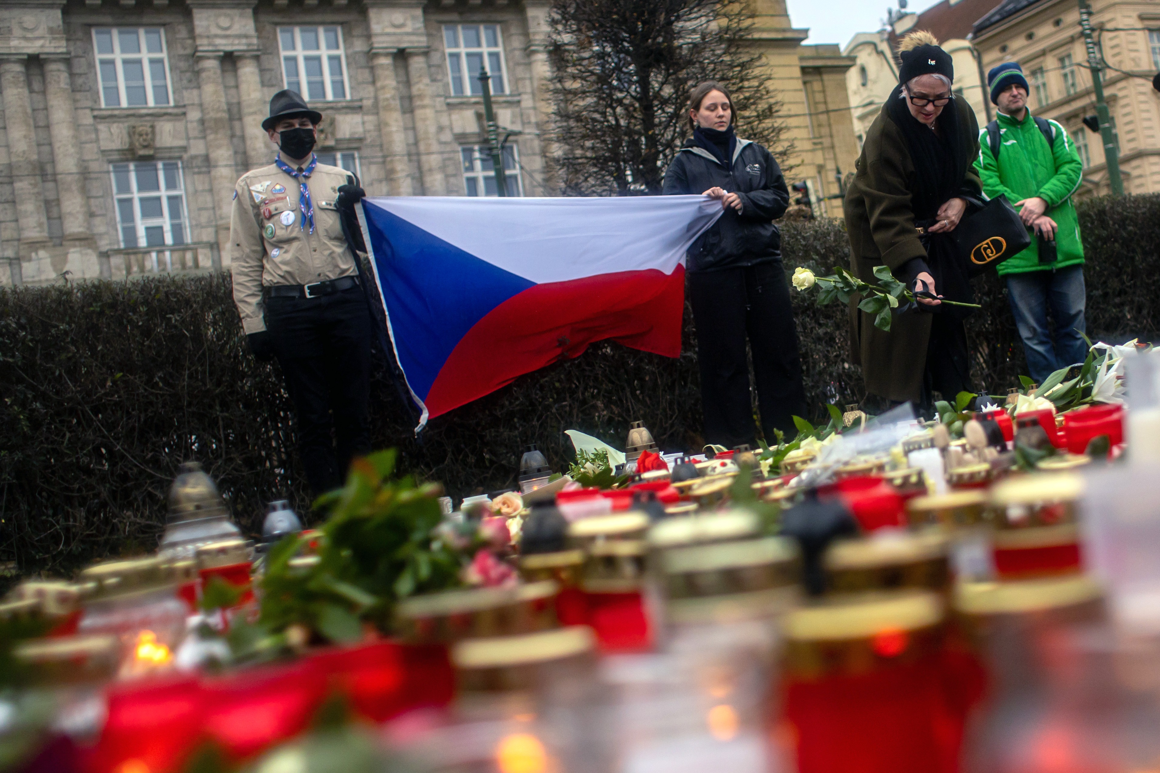 People pay respects a day after a shooting at Charles University in Prague