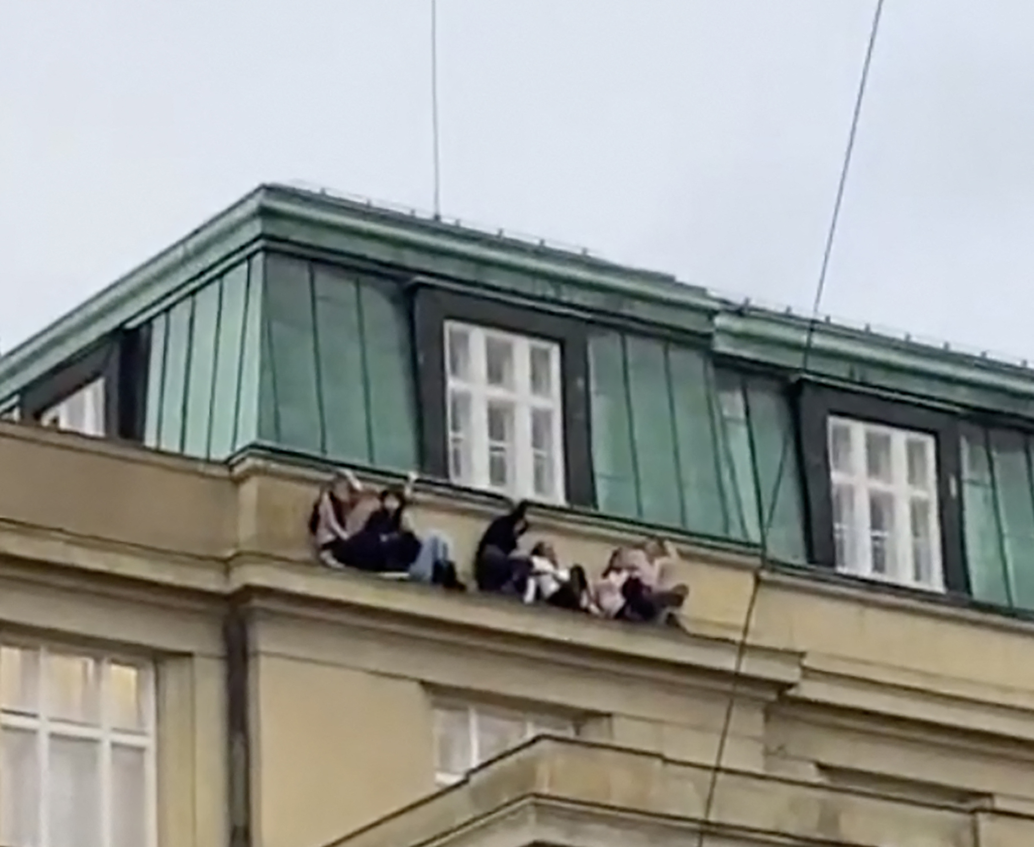 Students hide on a rooftop ledge during mass shooting which killed 15 people at a university in Prague.