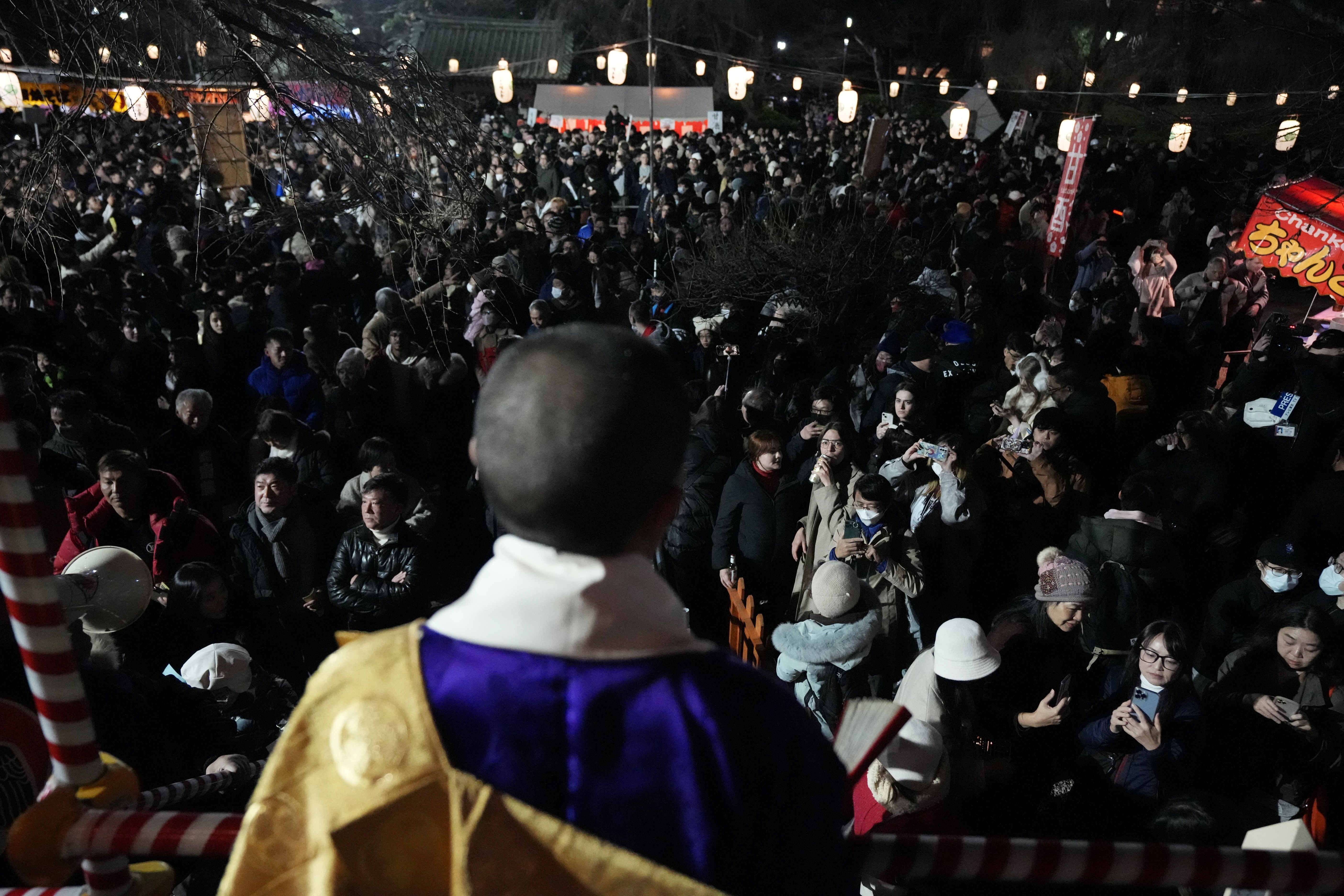 People gather at the Zojoji Buddhist temple in Tokyo to celebrate the New Year, early Monday, Jan. 1, 2024, in Tokyo. (AP Photo/Eugene Hoshiko)