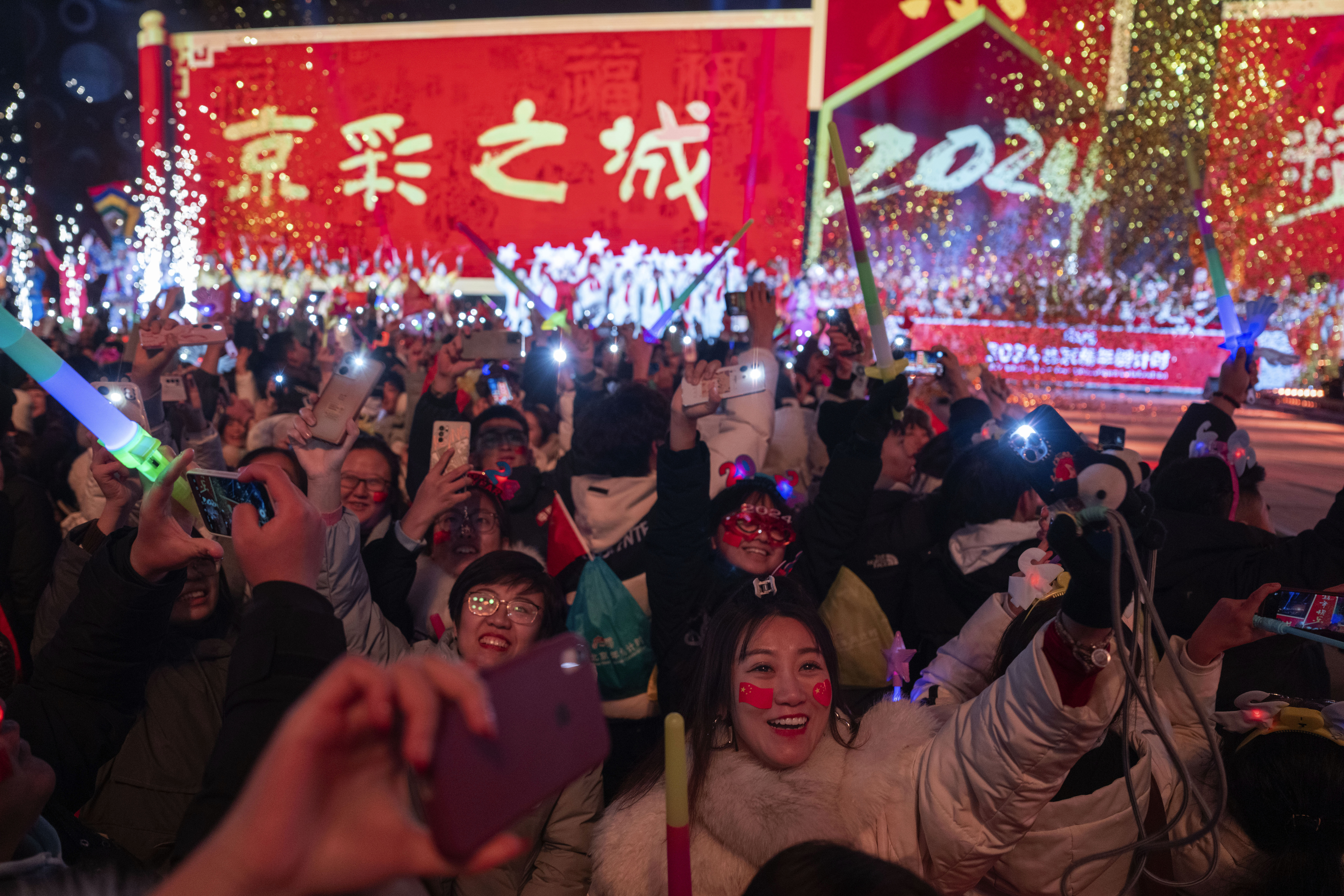 Revelers ring in the new year after a countdown to 2024 in Beijing, Monday, Jan. 1, 2024. (AP Photo/Ng Han Guan)