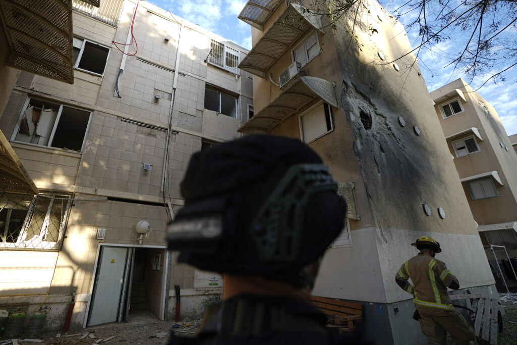Israeli security forces inspect a damaged residential building after it was hit by a rocket fired from the Gaza Strip, in Sderot, Israel, Tuesday, Oct. 17, 2023. (AP Photo/Ariel Schalit)
