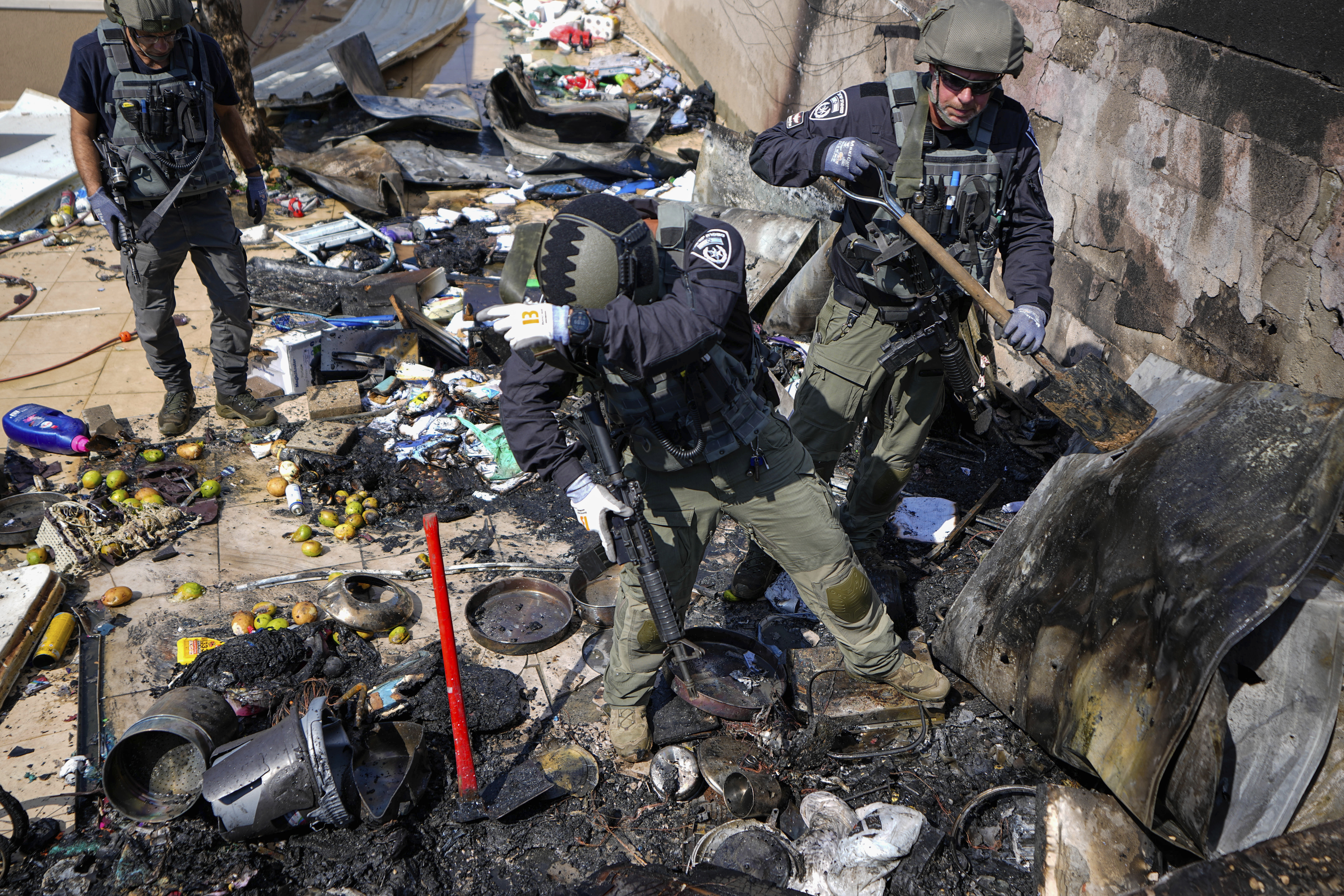 Israeli police extinguish fire at a site struck by a rocket fired from the Gaza Strip, in the southern Israeli town of Sderot, Sunday, Oct. 15, 2023. (AP Photo/Ariel Schalit)