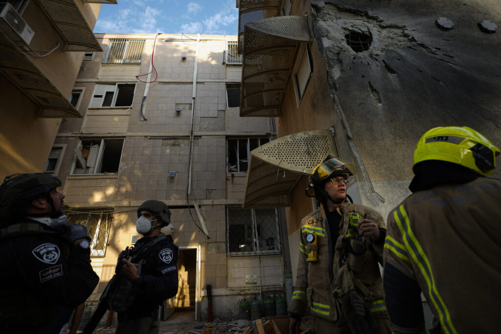 Israeli security forces inspect a damaged residential building after it was hit by a rocket fired from the Gaza Strip, in Sderot, Israel, Tuesday, Oct. 17, 2023. (AP Photo/Ariel Schalit)