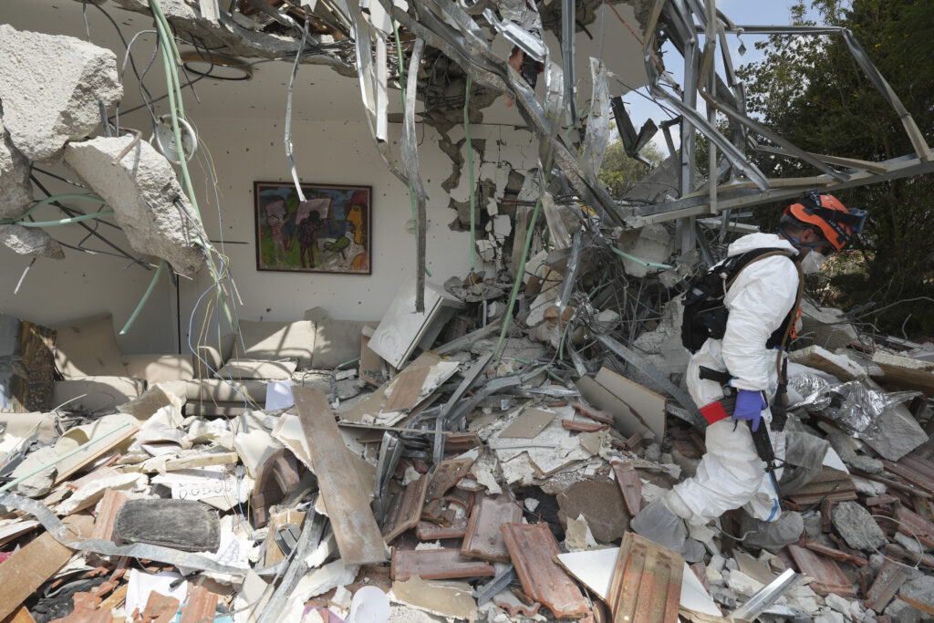 An Israeli soldier walks by a house destroyed by Hamas militants in Kibbutz Be'eri on Wednesday, Oct. 11, 2023. The kibbutz was overrun by Hamas militants from Neraby Gaza Strip Saturday when they killed and captured many Israelis. (AP Photo/Baz Ratner)
