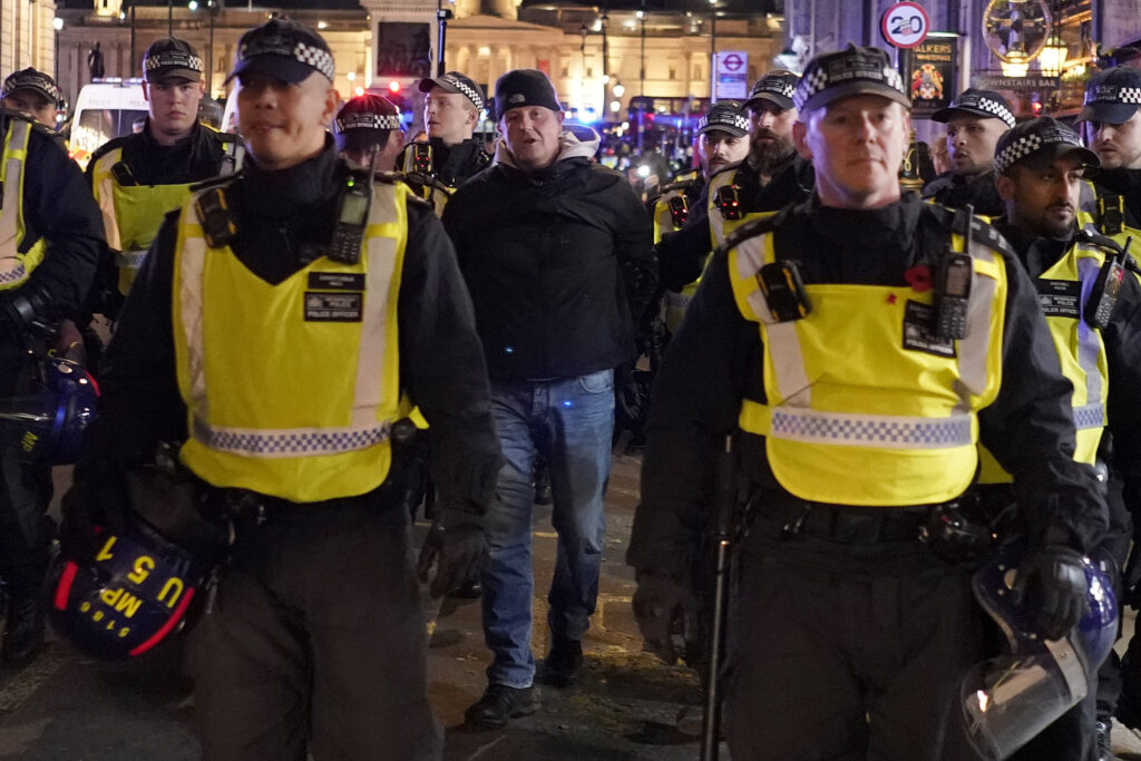 A counter-protester is arrested by police in London, Saturday, Nov. 11, 2023, after a pro-Palestinian protest march from Hyde Park to the US embassy in Vauxhall. (AP Photo/Alberto Pezzali)