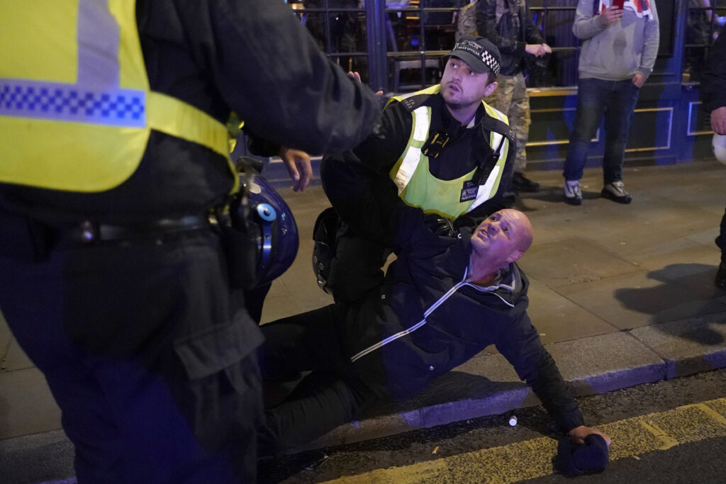A counter-protester is arrested by police in London, Saturday, Nov. 11, 2023, after a pro-Palestinian protest march from Hyde Park to the US embassy in Vauxhall. (AP Photo/Alberto Pezzali)