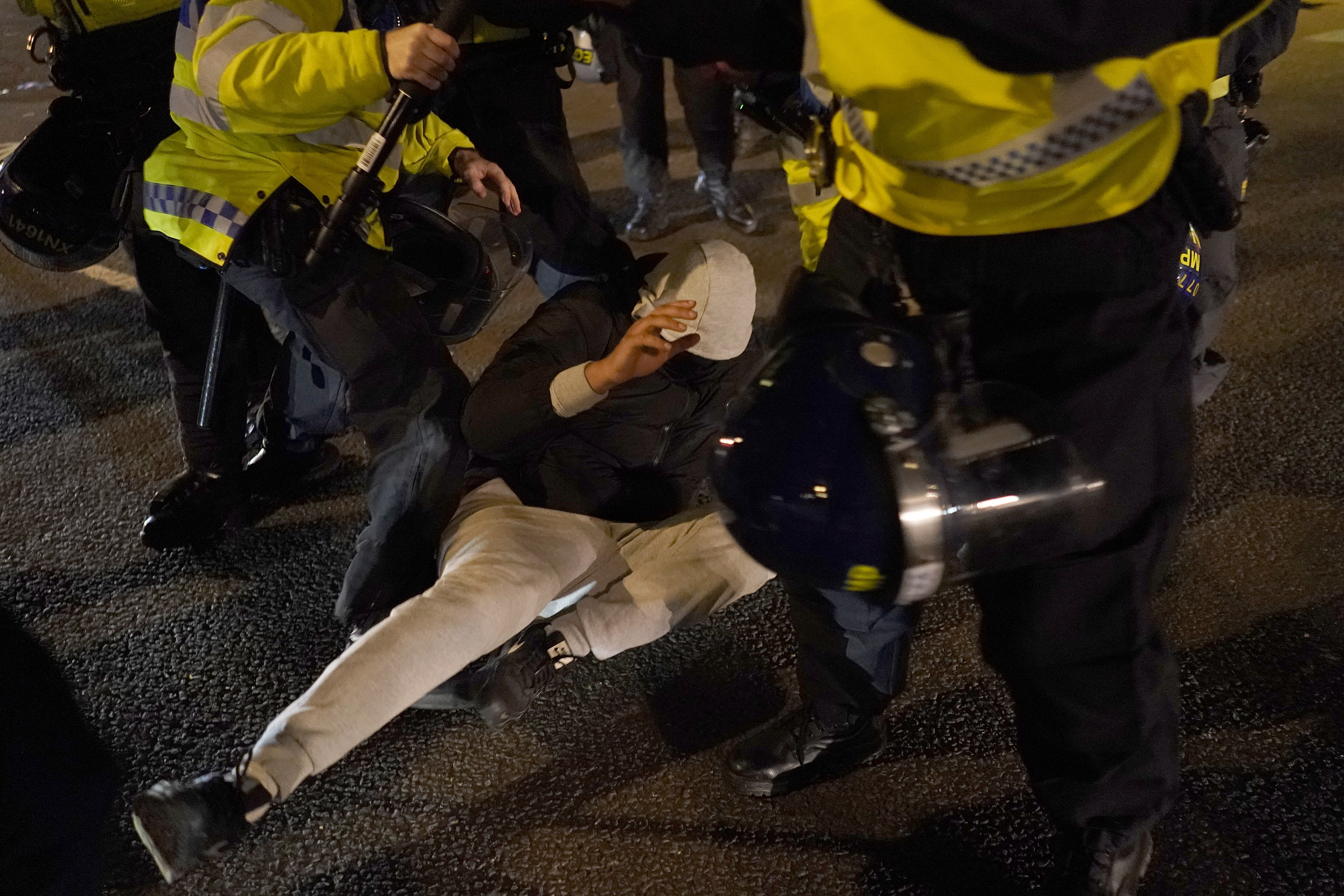 A counter-protester and police in Parliament Square in London, Saturday, Nov. 11, 2023, after a pro-Palestinian protest march from Hyde Park to the US embassy in Vauxhall. (AP Photo/Alberto Pezzali)