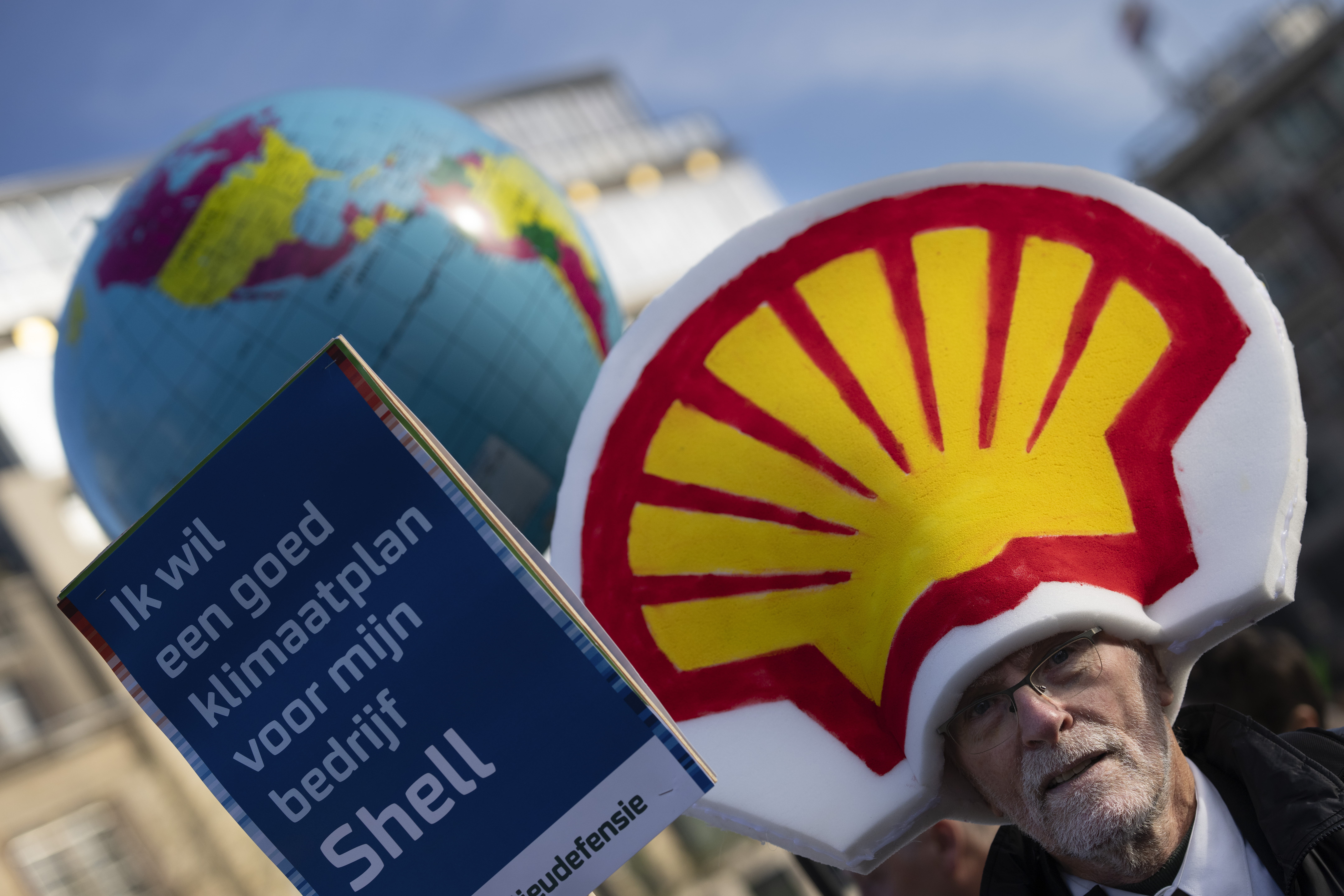 A man holds a placard reading "I want a good climate plan for my company Shell" as people gather for a climate march in Amsterdam, Netherlands, Sunday, Nov. 12, 2023. (AP Photo/Peter Dejong)
