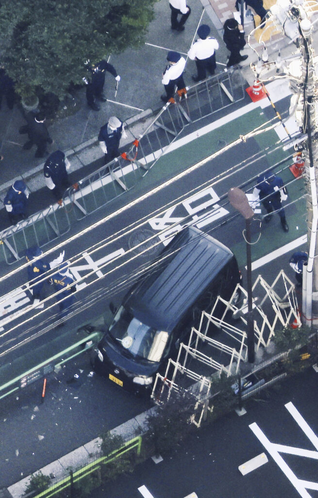 Investigators work near the vehicle which crashed into a temporary barricade near the Israeli Embassy in Tokyo Thursday, Nov. 16, 2023. Reports say police arrested the driver. (Kyodo News via AP)