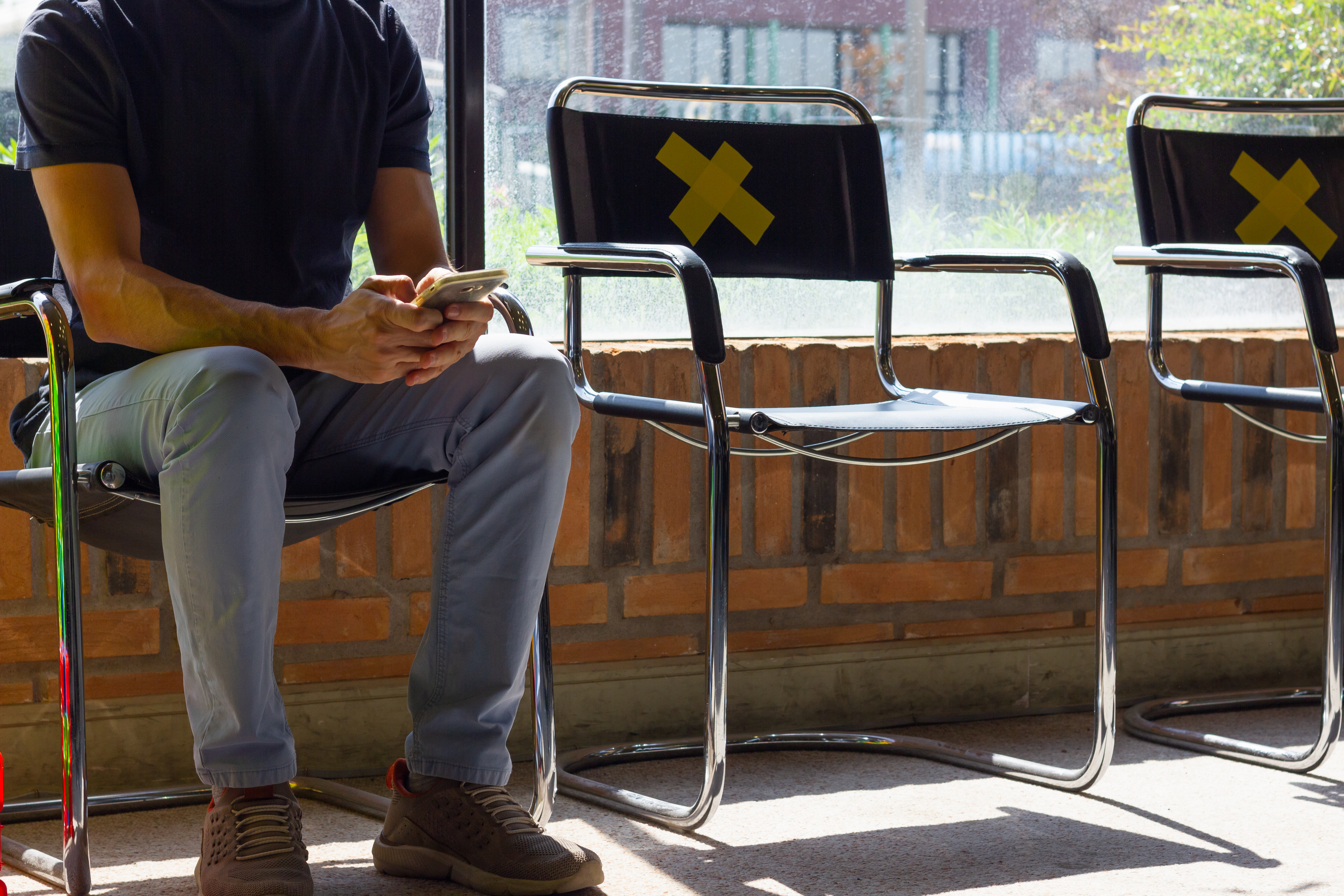 Anonymous,Man,Sitting,Down,Using,Cell,Phone,At,Doctor's,Waiting