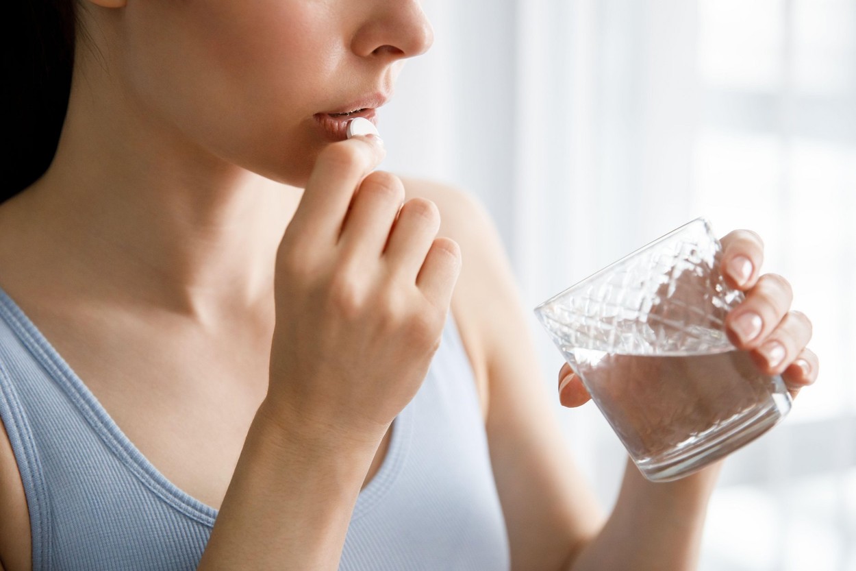 A young woman drinks medicine and holds a glass of water,Image: 665587109, License: Royalty-free, Restrictions: , Model Release: yes, Credit line: Combine Harvester / Alamy / Alamy / Profimedia