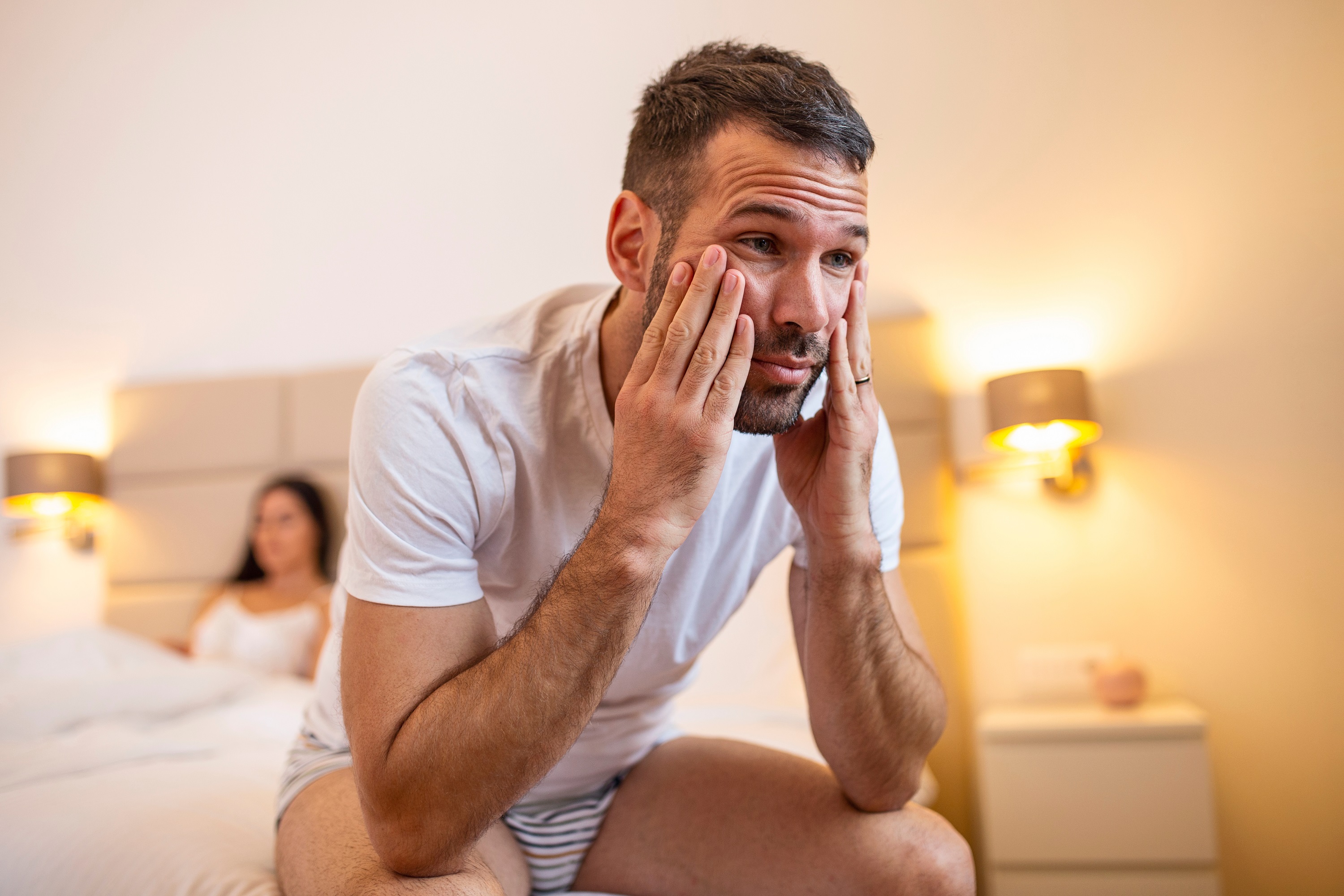 Young,Couple,Lying,In,Bed,Under,Blanket,In,Bedroom,At