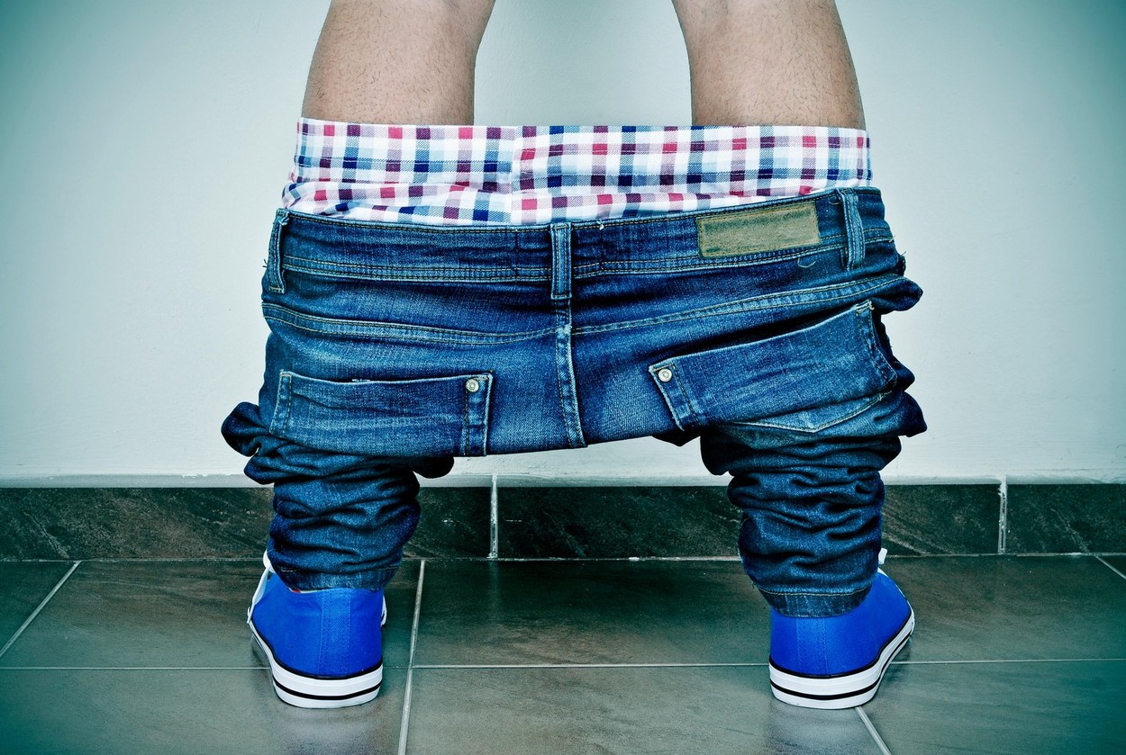 closeup of a young caucasian man with his denim pants and his underwear down, seen from behind