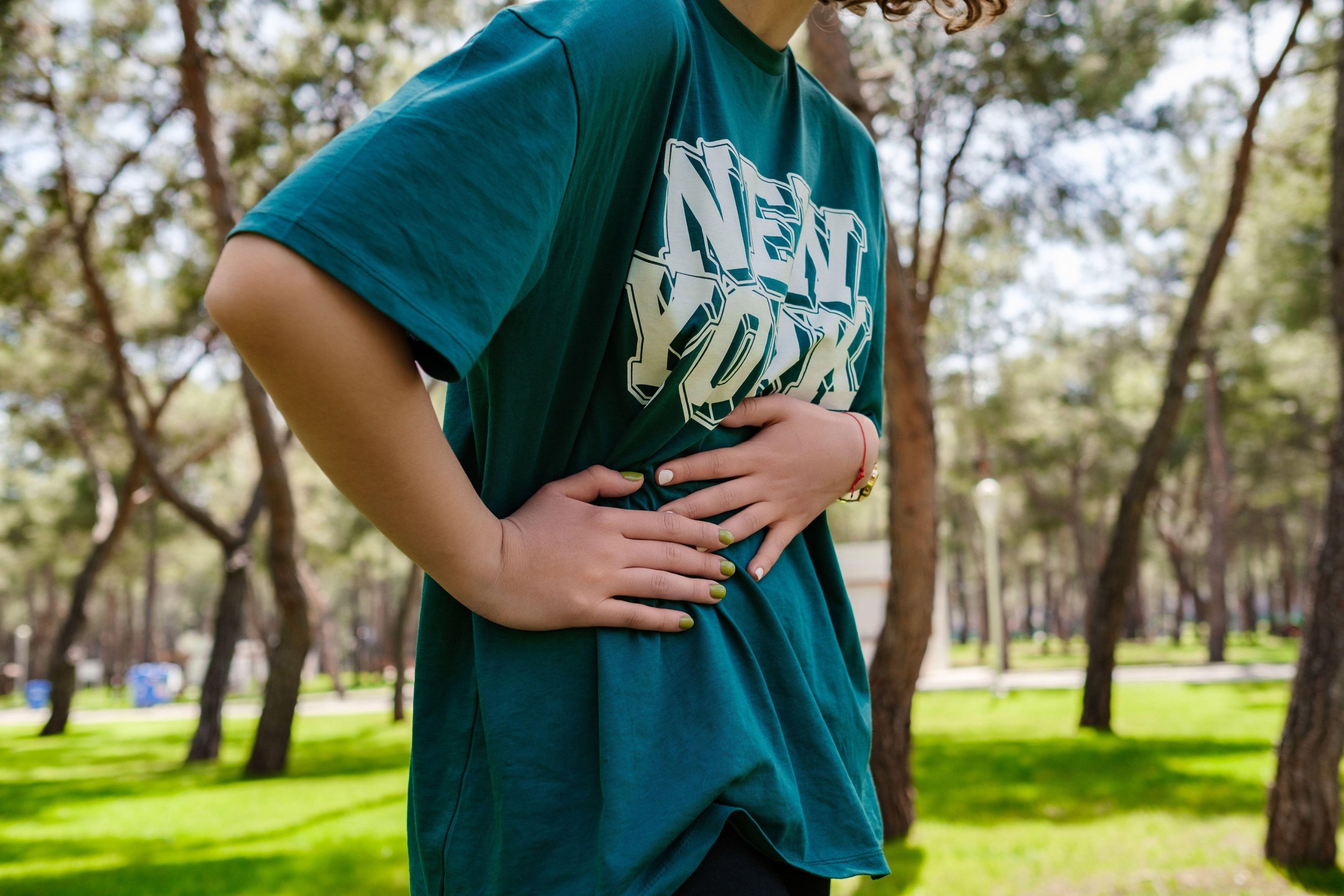 Redhead woman runner side cramps after running. Side stitch, Jogging woman with stomach side pain after jogging work out. Woman has a stomachache outd