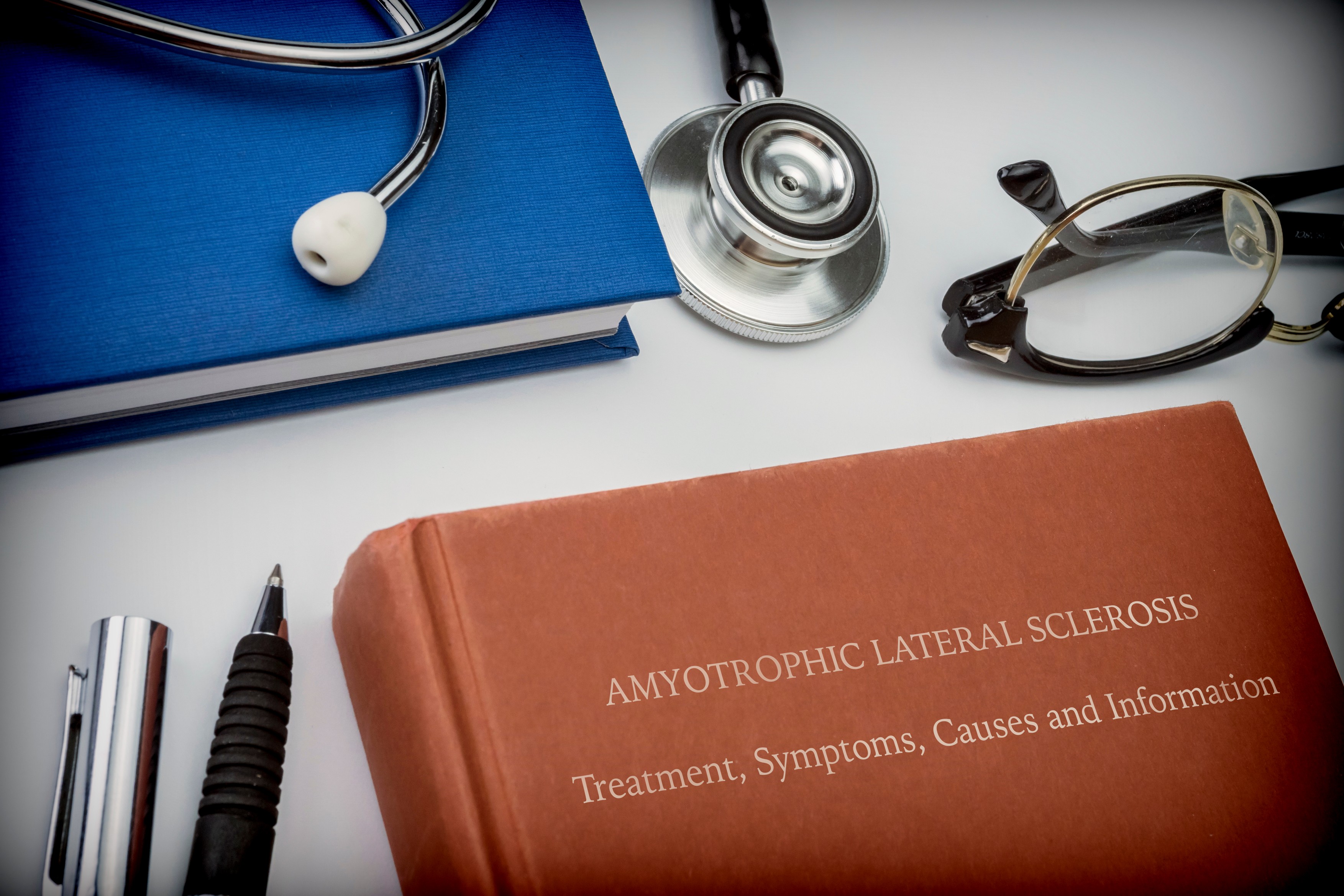 Conceptual image of a book entitled amyotrophic lateral sclerosis along with medical equipment.,Image: 742938170, License: Royalty-free, Restrictions: , Model Release: no, Credit line: DIGICOMPHOTO / Sciencephoto / Profimedia