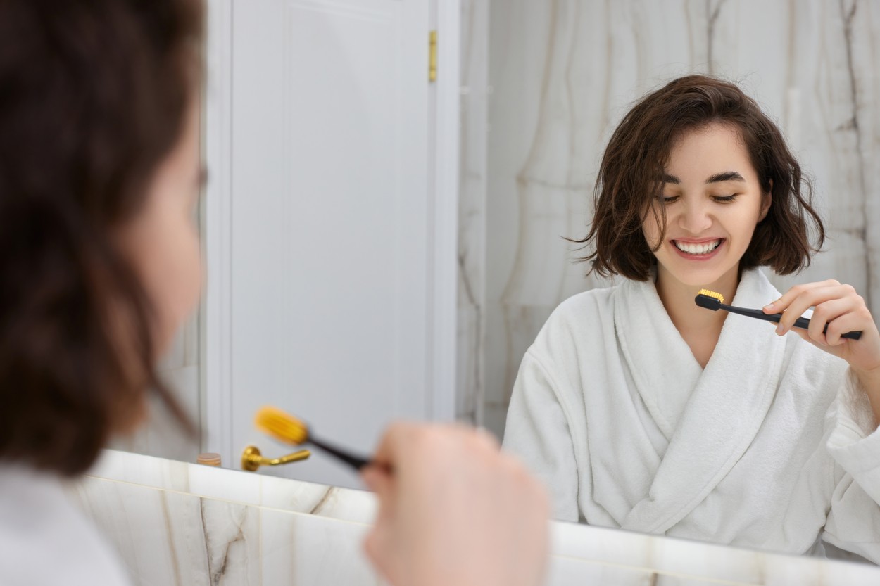 beautiful happy woman holding toothbrush with paste in front of mirror in bathroom,Image: 628021424, License: Royalty-free, Restrictions: , Model Release: yes, Credit line: Yevhen Rychko / Panthermedia / Profimedia