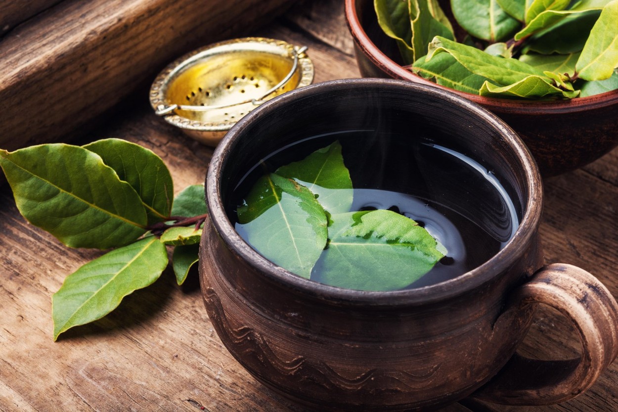 .Delicious herbal tea with bay leaf on wooden background