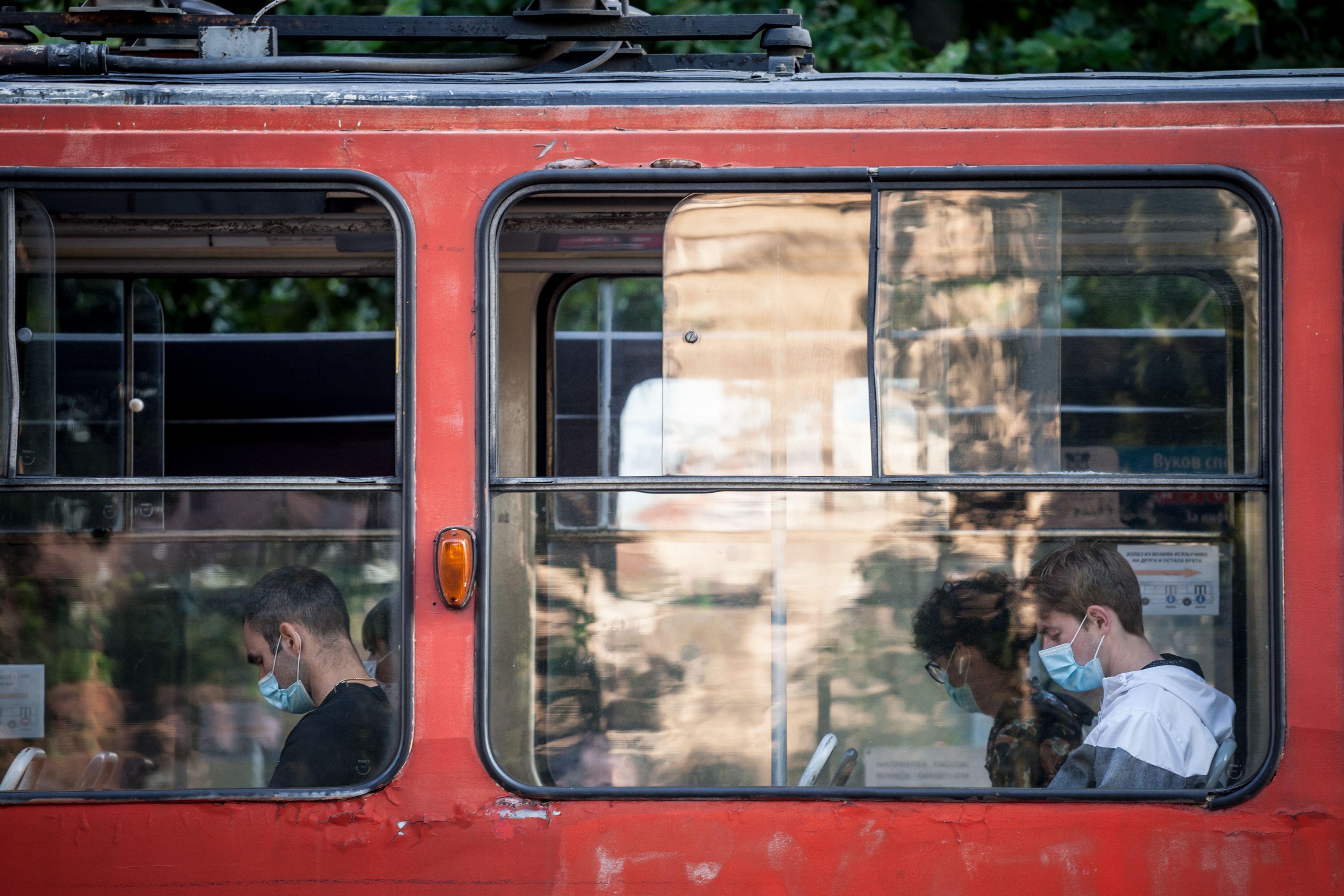 BELGRADE, SERBIA - JULY 8 2020: Young man at the window of a tram wearing a respiratory face mask in public transportation in Belgrade, during the cor