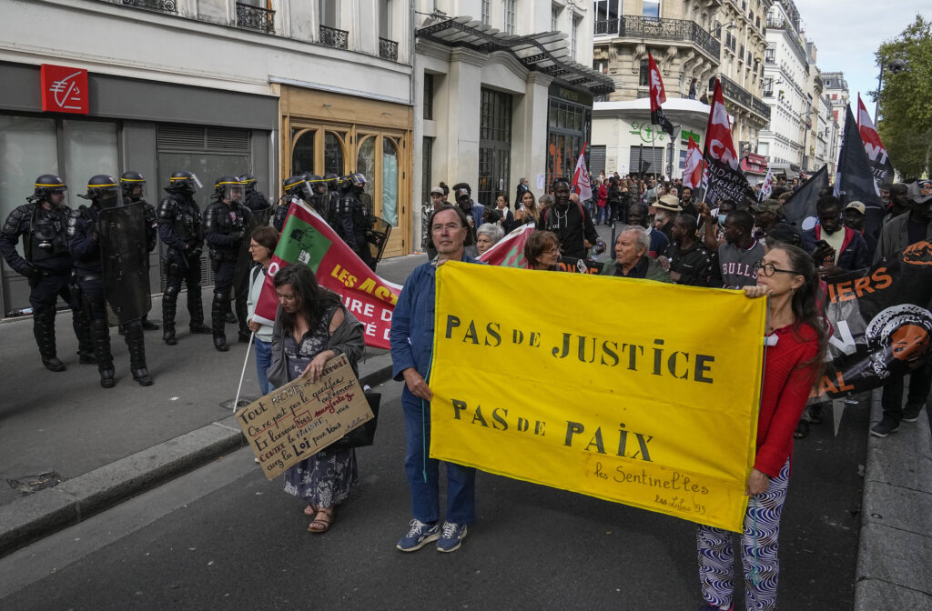 People march with a banner that reads, "no justice, no peace,"  in Paris, Saturday, Sept. 23, 2023. Activists from community groups, far-left parties and unions have held marches around France against racism and police brutality. (AP Photo/Michel Euler)