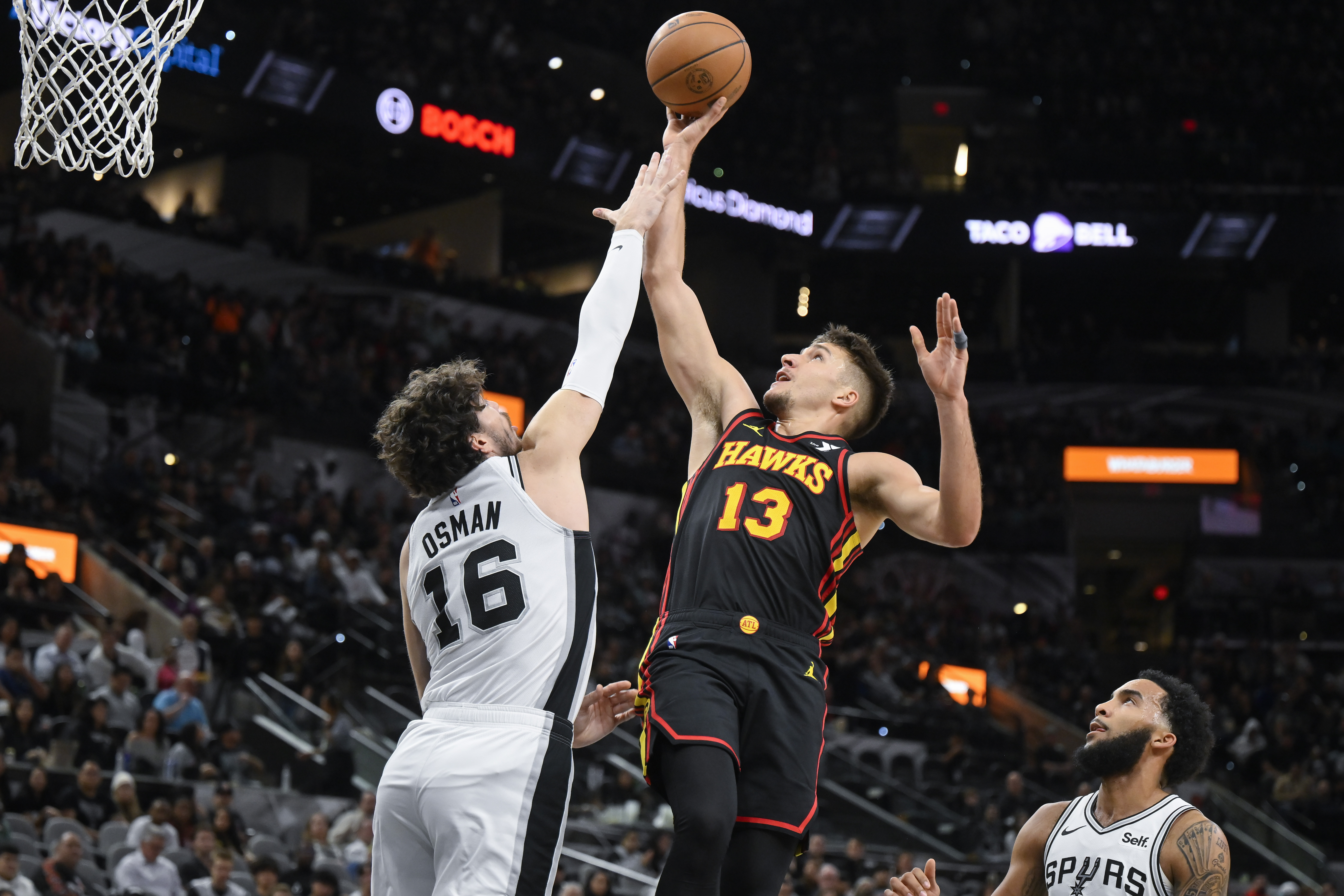 Atlanta Hawks' Bogdan Bogdanovic (13) goes to the basket against San Antonio Spurs' Cedi Osman during the first half of an NBA basketball game Thursday, Nov. 30, 2023, in San Antonio. (AP Photo/Darren Abate)