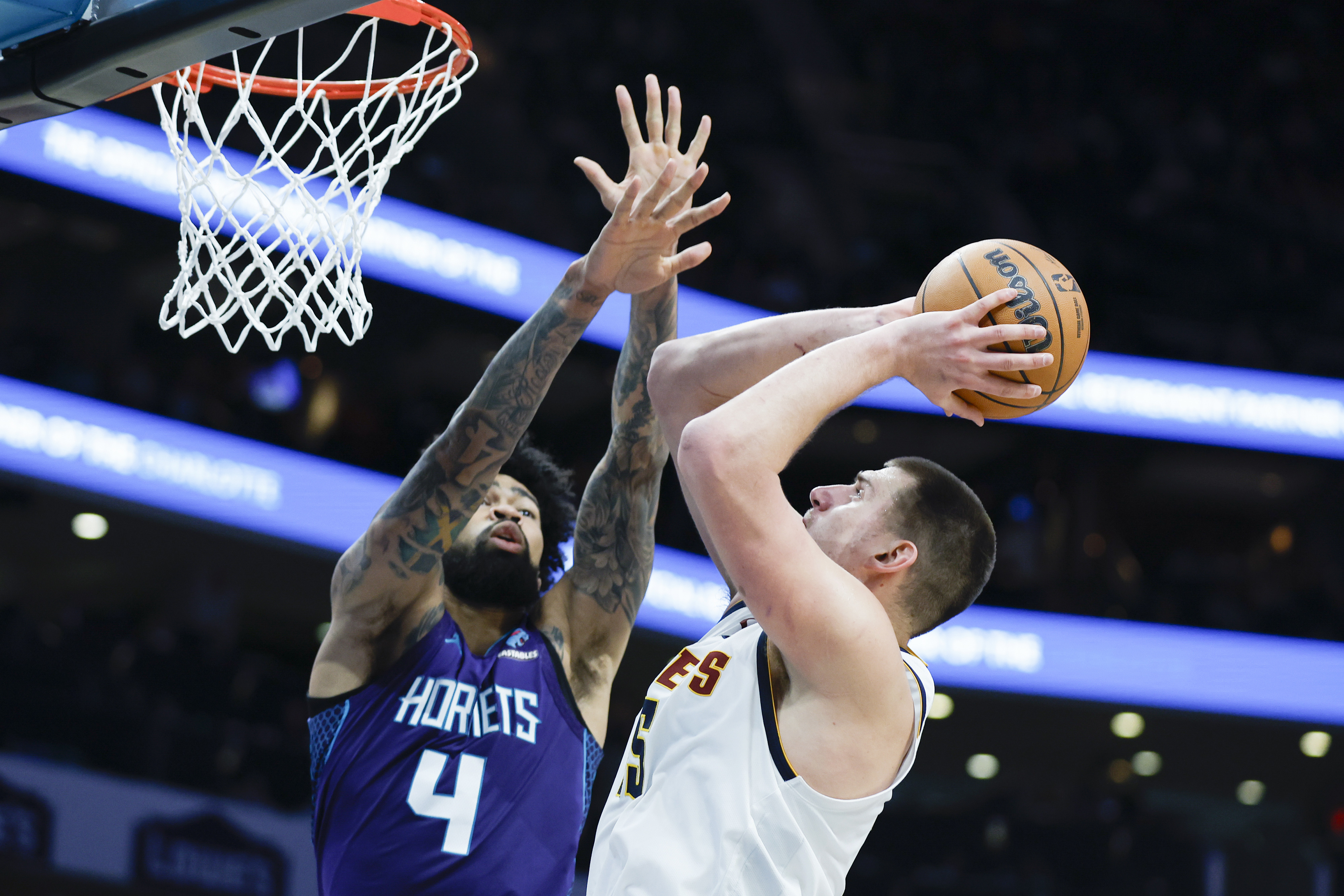Denver Nuggets center Nikola Jokic, right, shoots over Charlotte Hornets center Nick Richards during the second half of an NBA basketball game in Charlotte, N.C., Saturday, Dec. 23, 2023. (AP Photo/Nell Redmond)