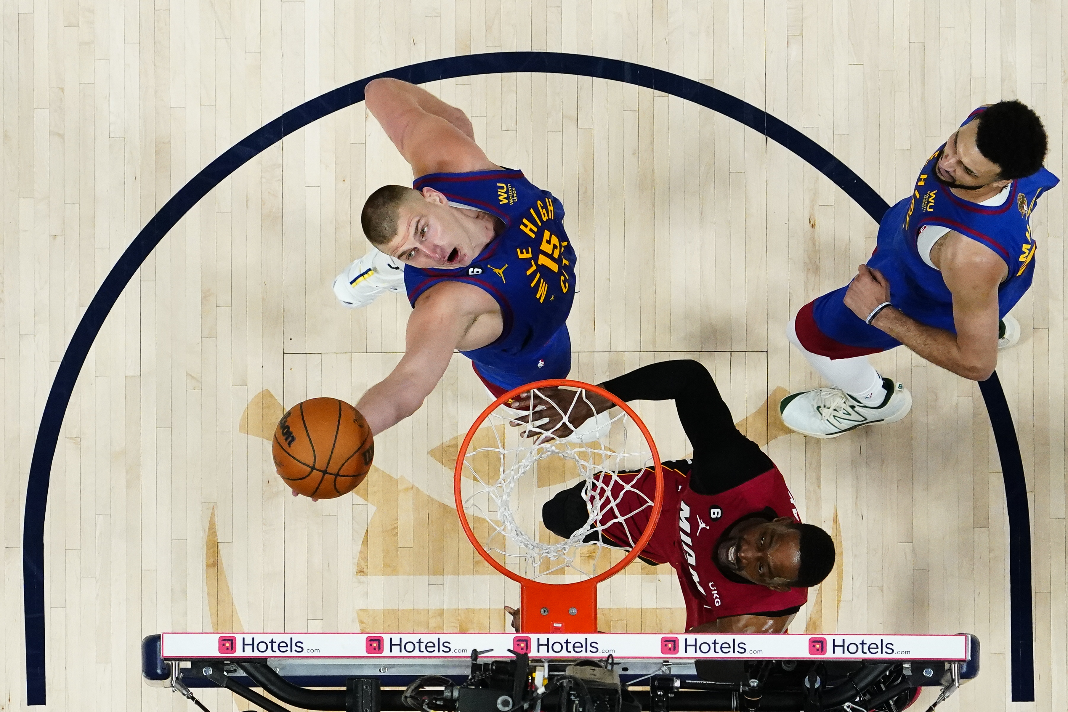Denver Nuggets center Nikola Jokic (15) reaches for a rebound next to Miami Heat center Bam Adebayo during the second half of Game 1 of basketball's NBA Finals, Thursday, June 1, 2023, in Denver. (AP Photo/Jack Dempsey, Pool)