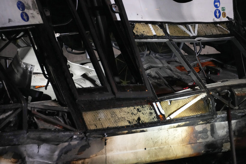 Italian firefighters work at the scene of a passenger bus accident in Mestre, near the city of Venice, Italy, Wednesday, Oct. 4, 2023. The bus fell from an elevated road, late Tuesday, killing multiple people. (AP Photo/Antonio Calanni)