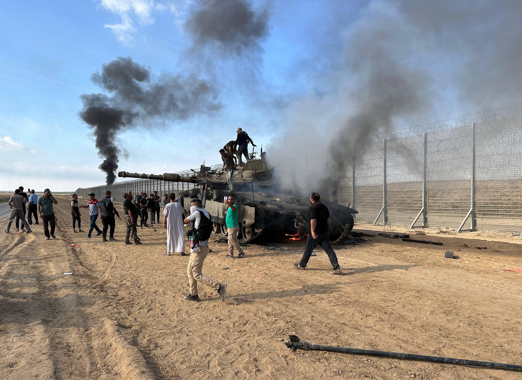 Palestinian members of the Ezz Al-Din Al Qassam Brigades, the military wing of Hamas burn military armored vehicle