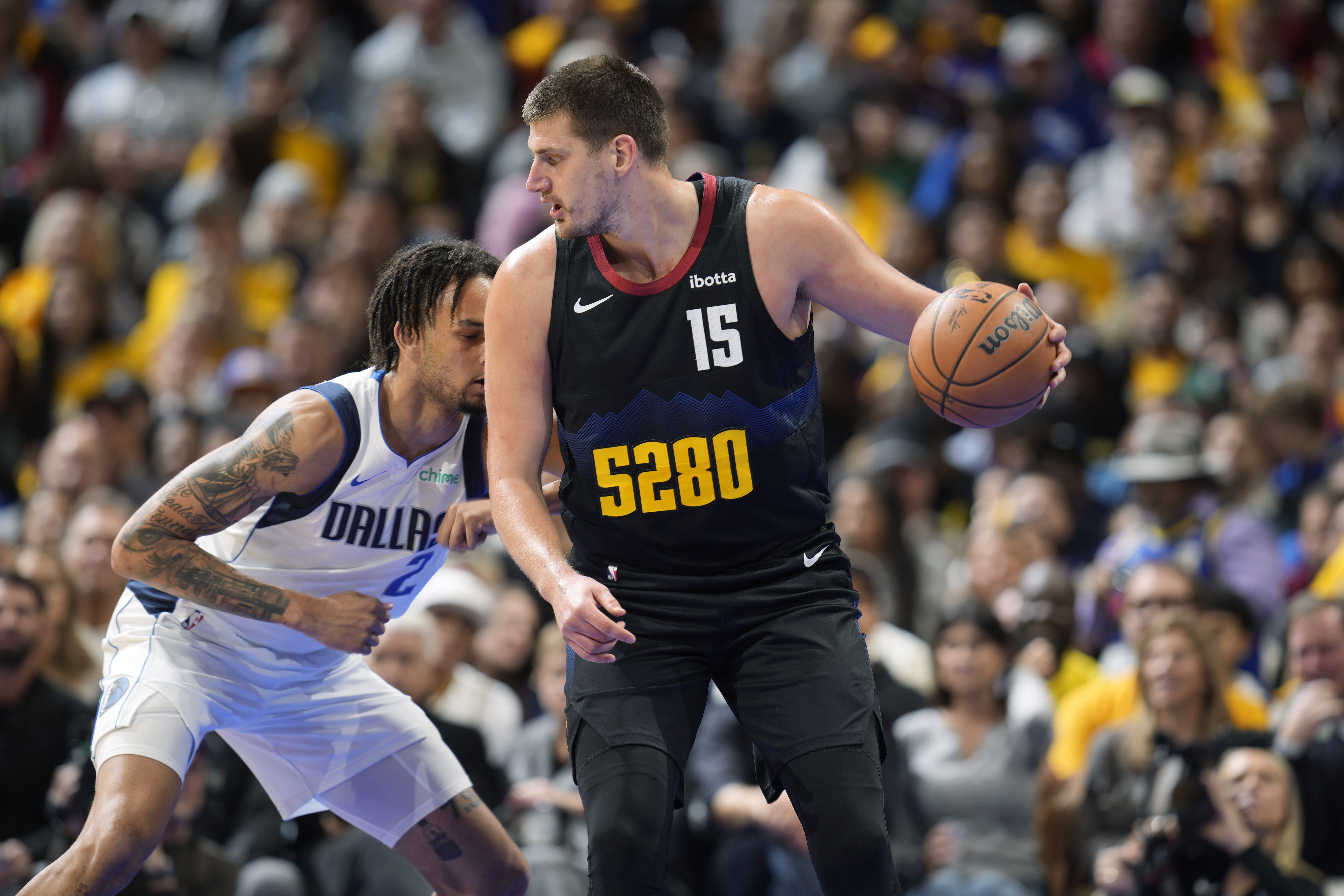 Denver Nuggets center Nikola Jokic, right, looks to pass the ball as Dallas Mavericks center Dereck Lively II defends during the first half of an NBA basketball in-season tournament game Friday, Nov. 3, 2023, in Denver. (AP Photo/David Zalubowski)