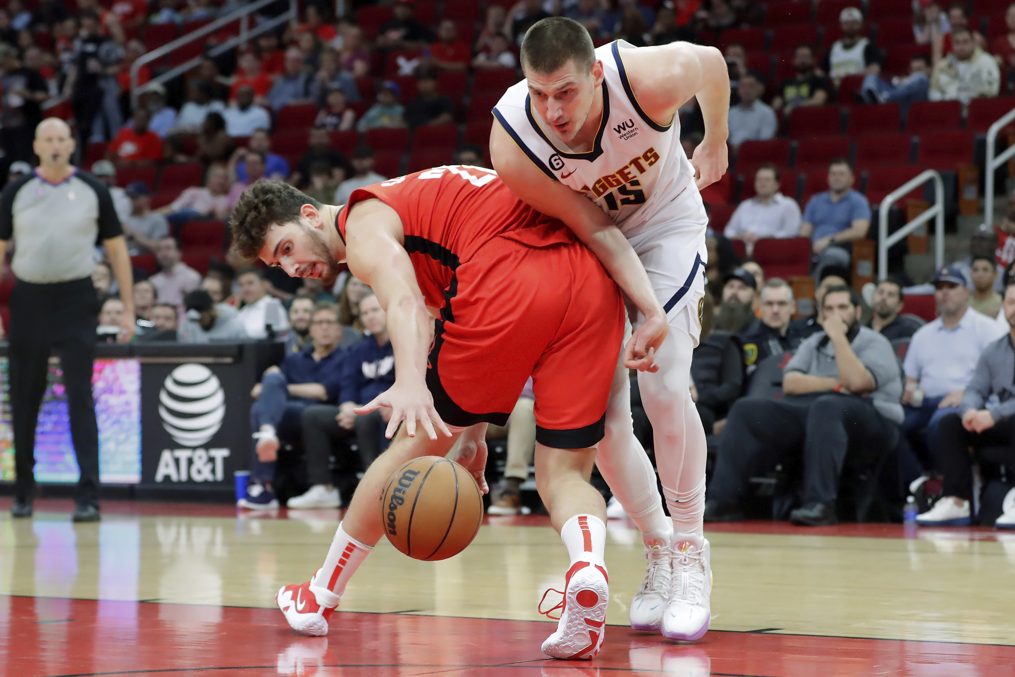 Houston Rockets center Alperen Sengun, left, loses control of the ball as Denver Nuggets center Nikola Jokic, right, attempts to recover during the first half of an NBA basketball game, Tuesday, April 4, 2023, in Houston. (AP Photo/Michael Wyke)