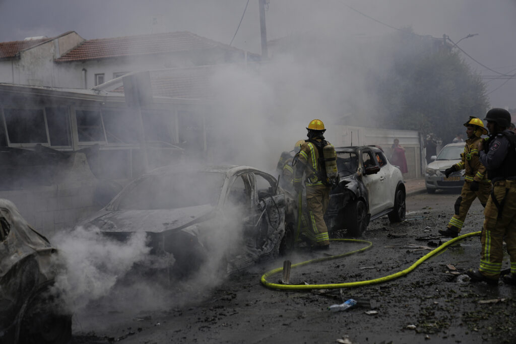Israeli firefighters extinguish fire at a site struck by a rocket fired from the Gaza Strip, in Ashkelon, southern Israel, Monday, Oct. 9, 2023. (AP Photo/Ohad Zwigenberg)