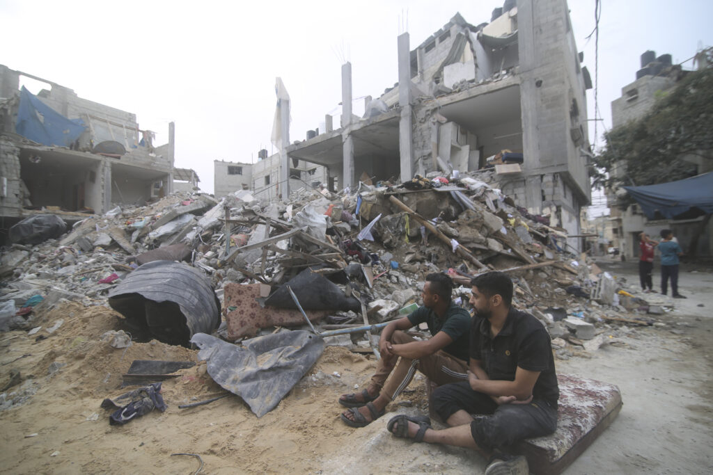 Palestinians isit by the rubble Abu Helal family in Rafah refugee camp, Gaza Strip, Monday, Oct. 9, 2023. The strike killed dozens of people.(AP Photo/Hatem Ali)