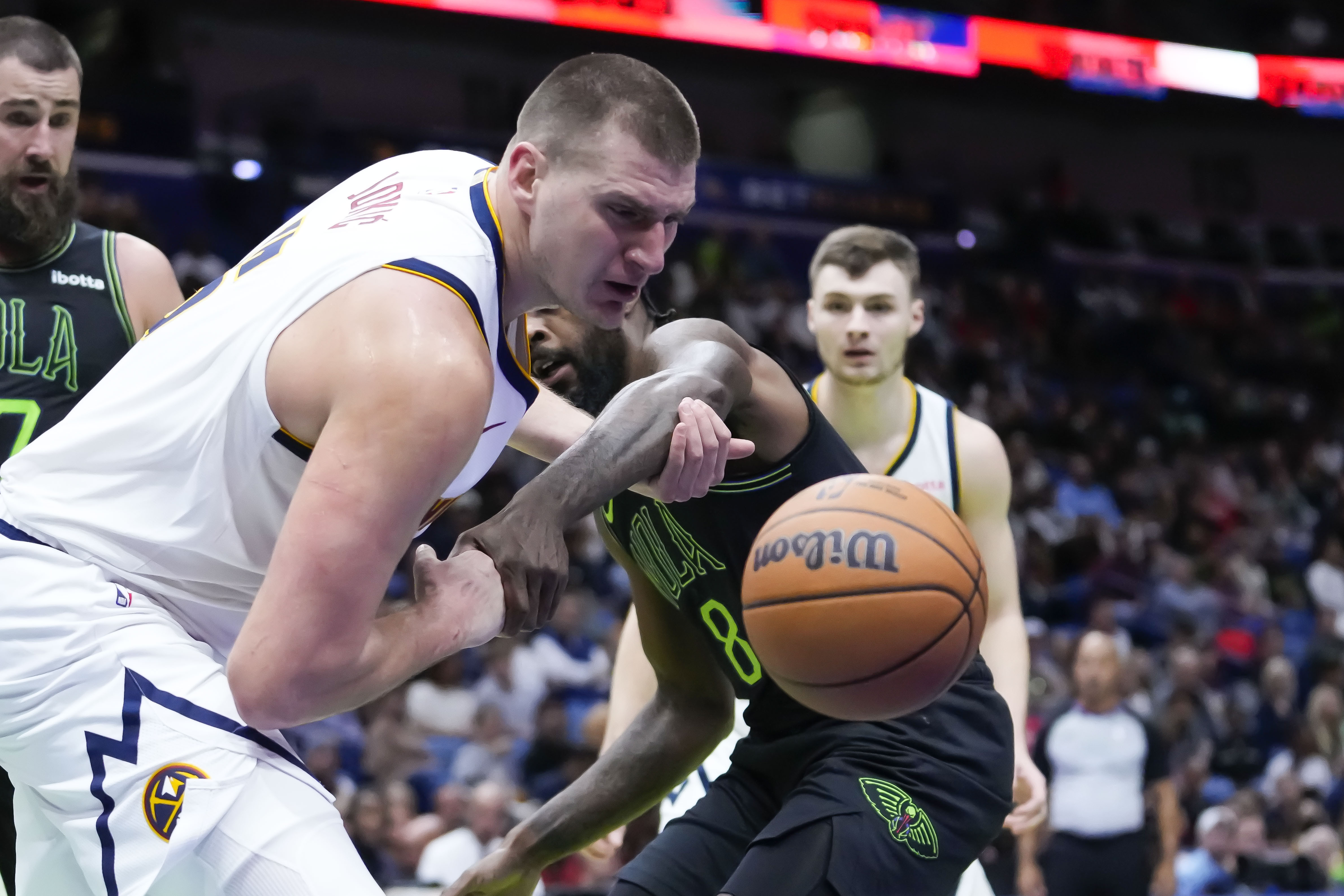 Denver Nuggets center Nikola Jokic and New Orleans Pelicans forward Naji Marshall (8) battle for a loose ball in the first half of an NBA basketball game in New Orleans, Friday, Nov. 17, 2023. (AP Photo/Gerald Herbert)