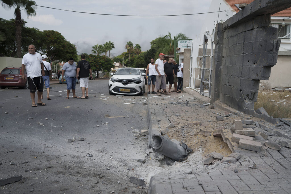 Israelis look at the damage caused by rocket fire from the Gaza Strip in Ashkelon, southern Israel, Wednesday, Oct. 11, 2023. (AP Photo/Leo Correa)