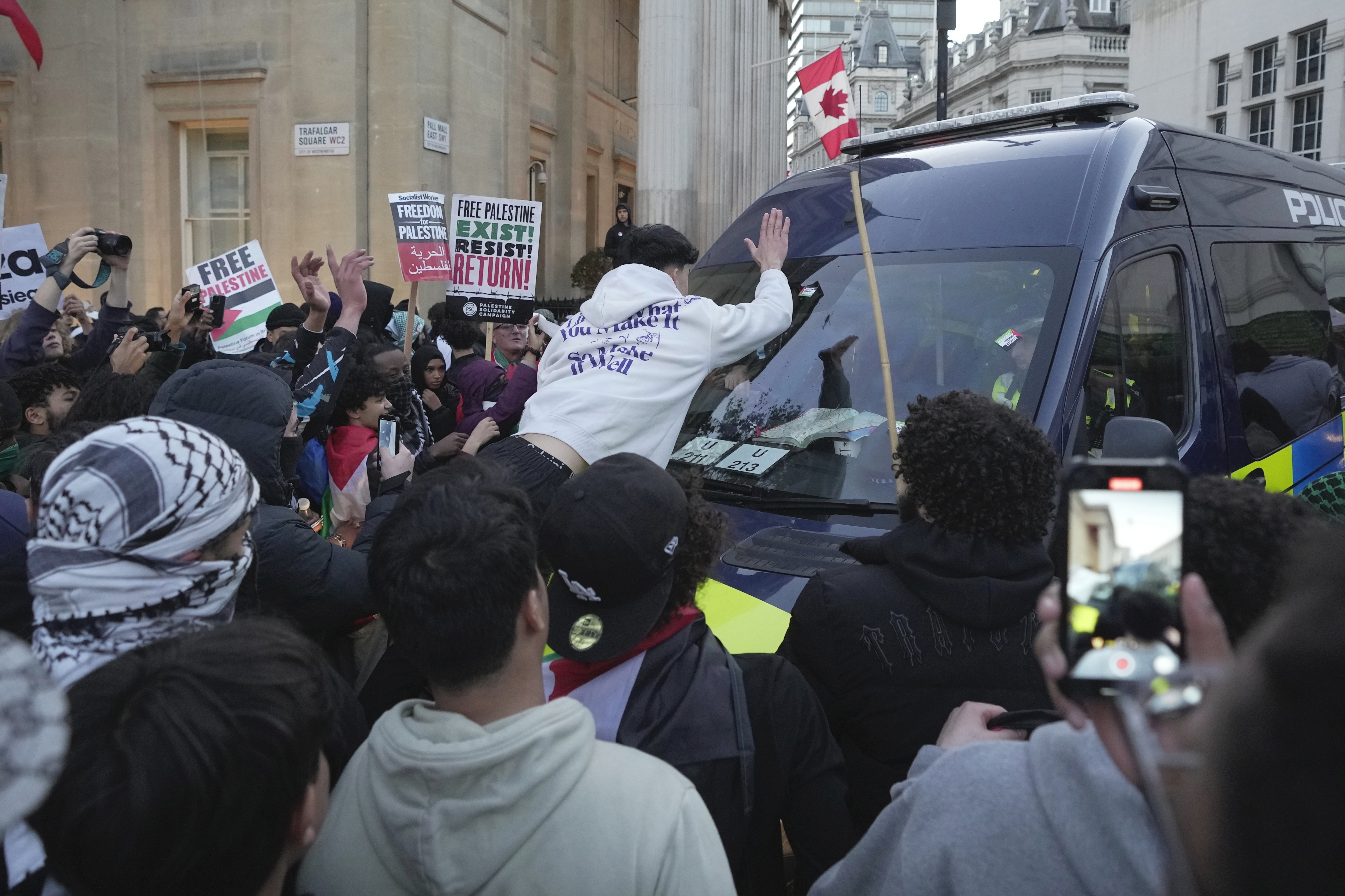 A protester hist a police van during a pro Palestinian demonstration in London, Saturday, Oct. 14, 2023, in support of Palestinians caught up in the war between Israel and Hamas. (AP Photo/Kin Cheung)