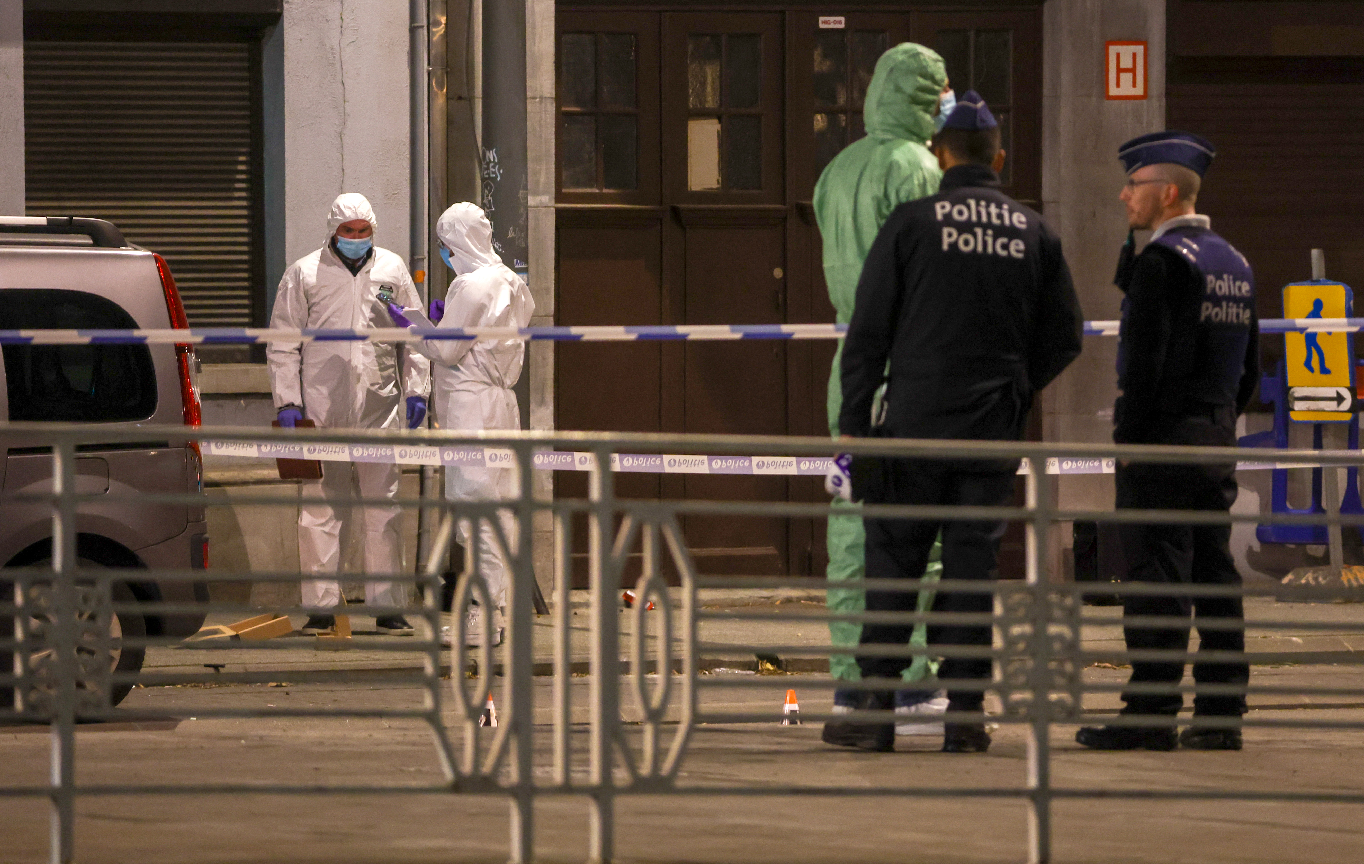 epa10922555 Belgian police officers and forensics work behing a cordon at the scene of a shooting in Brussels, Belgium, 16 October 2023. Two people have died after a shooting in Brussels on 16 October evening, Belgiam police said.  EPA-EFE/OLIVIER HOSLET