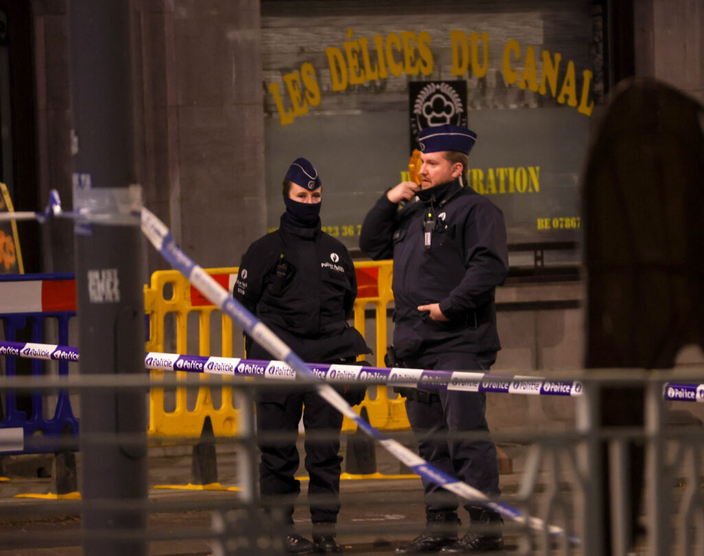 epa10922549 Belgian police officers keep watch behind a cordon at the scene of a shooting in Brussels, Belgium, 16 October 2023. Two people have shot dead in a shooting in Brussels on 16 October evening, Belgiam police said.  EPA-EFE/OLIVIER HOSLET