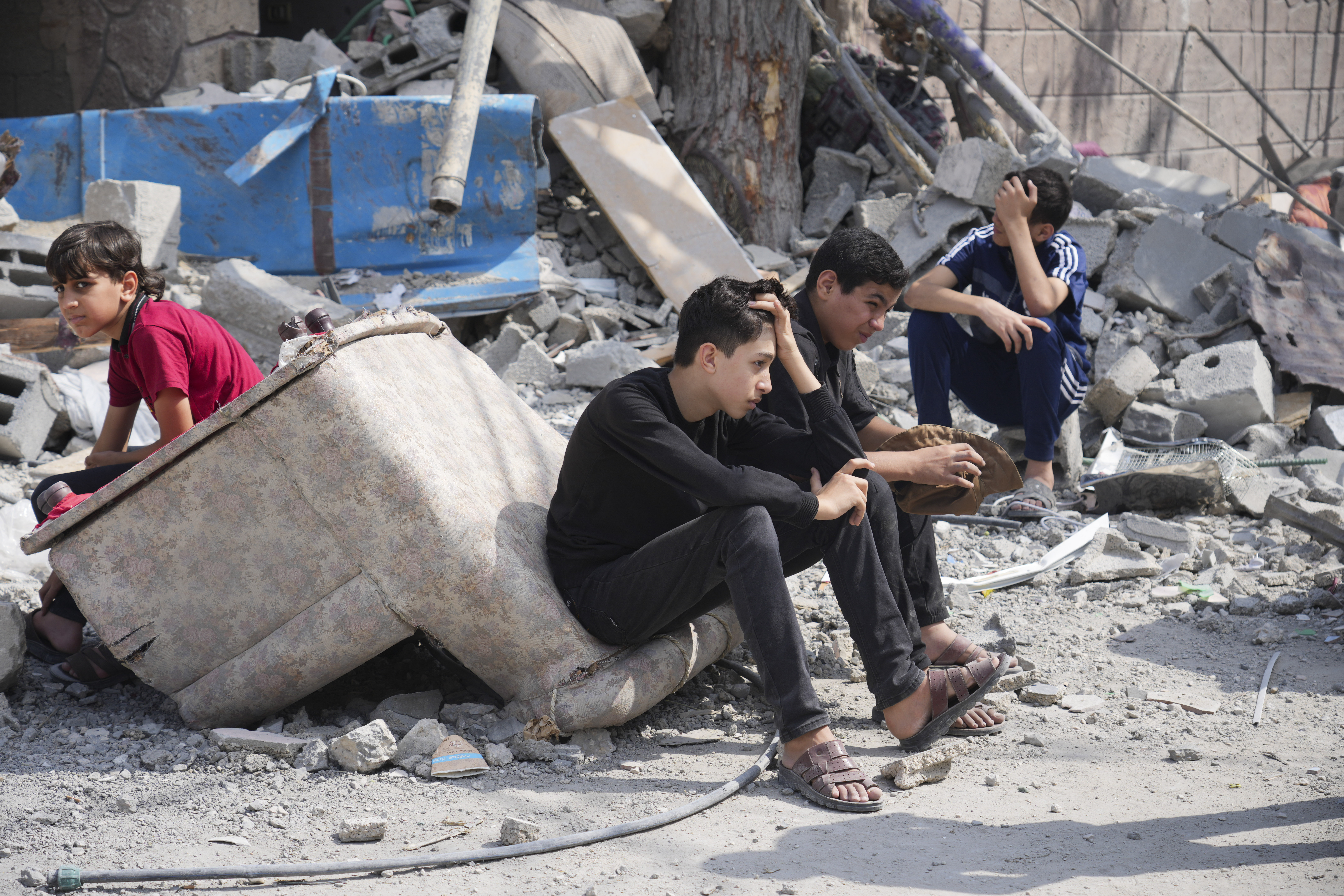 Palestinian boys sit on the rubble of a building destroyed in an Israeli airstrike in Nuseirat camp in the central Gaza Strip on Monday, Oct. 16, 2023. (AP Photo/Hatem Moussa)