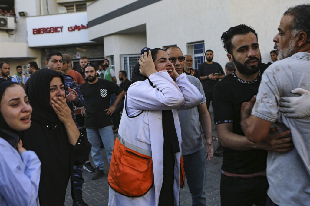 A Palestinian medic, center, and others cry after learning about the death of a relative at the al-Shifa hospital, following Israeli airstrikes on Gaza City, central Gaza Strip, Tuesday, Oct. 17, 2023. (AP Photo/Abed Khaled)