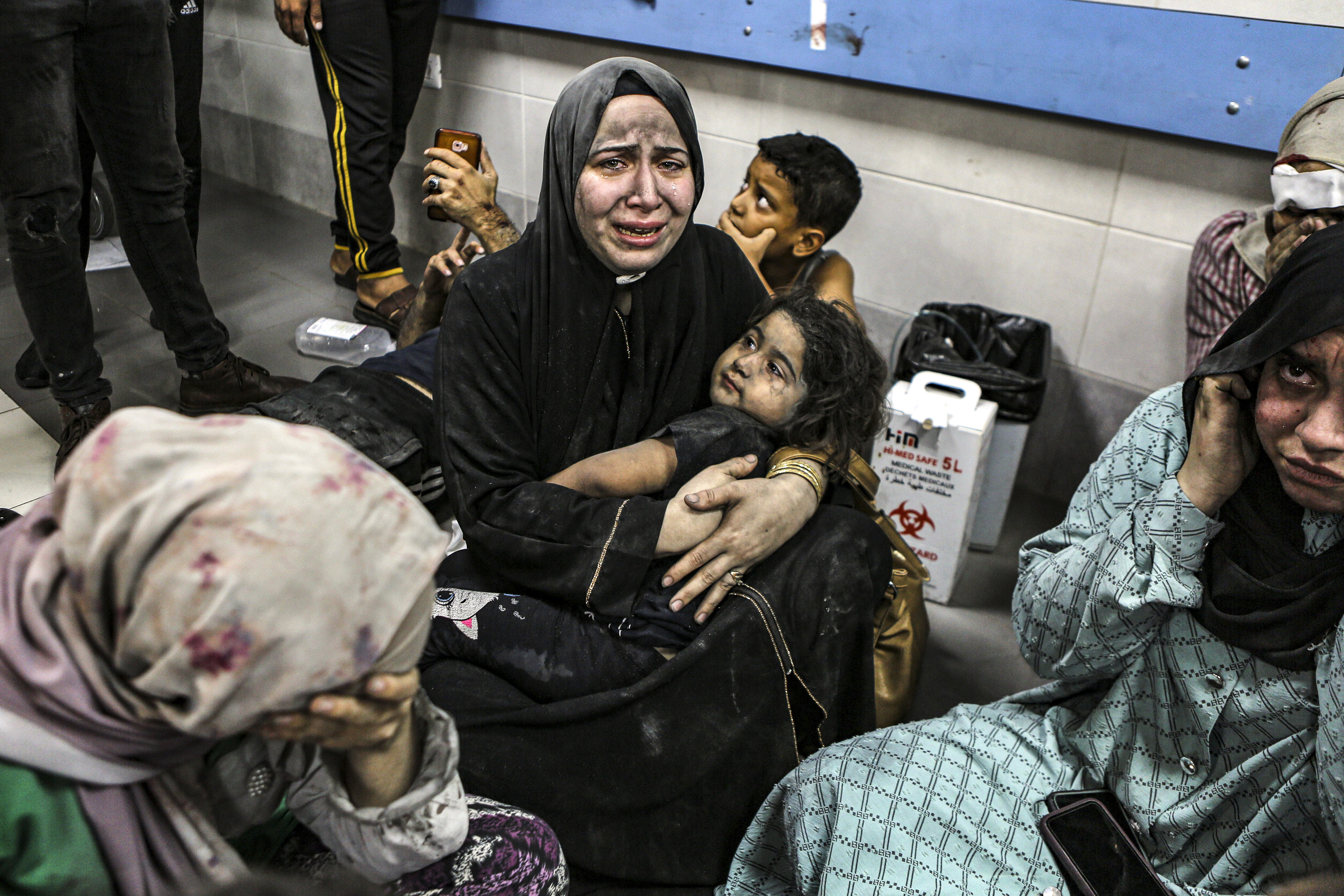 Wounded Palestinians sit on the floor at the al-Shifa hospital, following Israeli airstrikes, in Gaza City, central Gaza Strip, Tuesday, Oct. 17, 2023. (AP Photo/Abed Khaled)