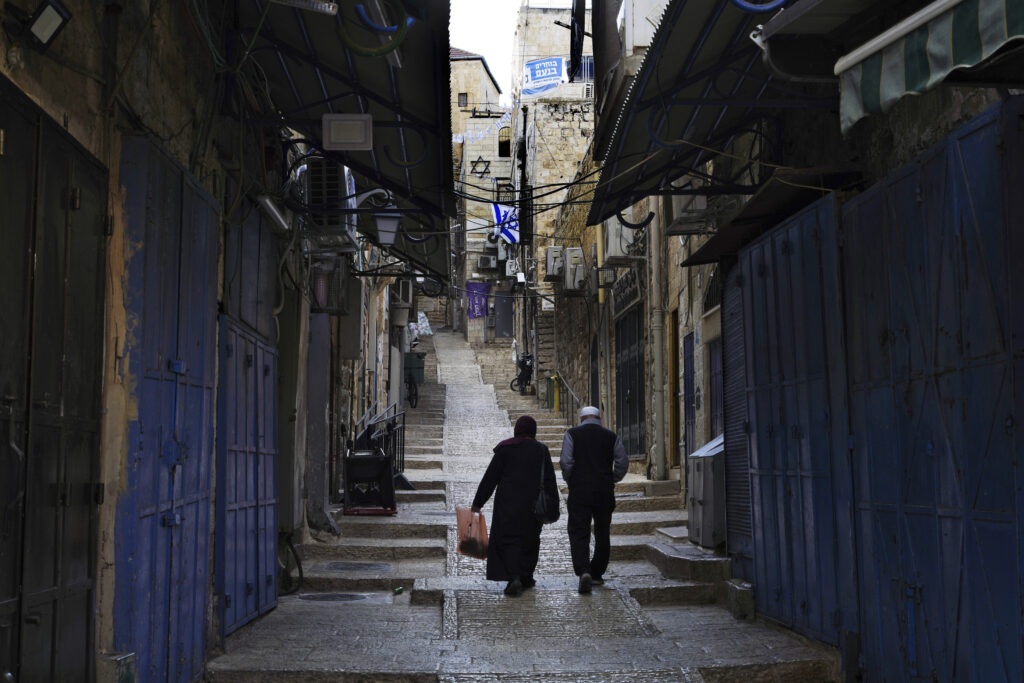 Palestinians walk past closed shops in the Old City of Jerusalem, Monday, Oct. 16, 2023. (AP Photo/Jon Gambrell)
