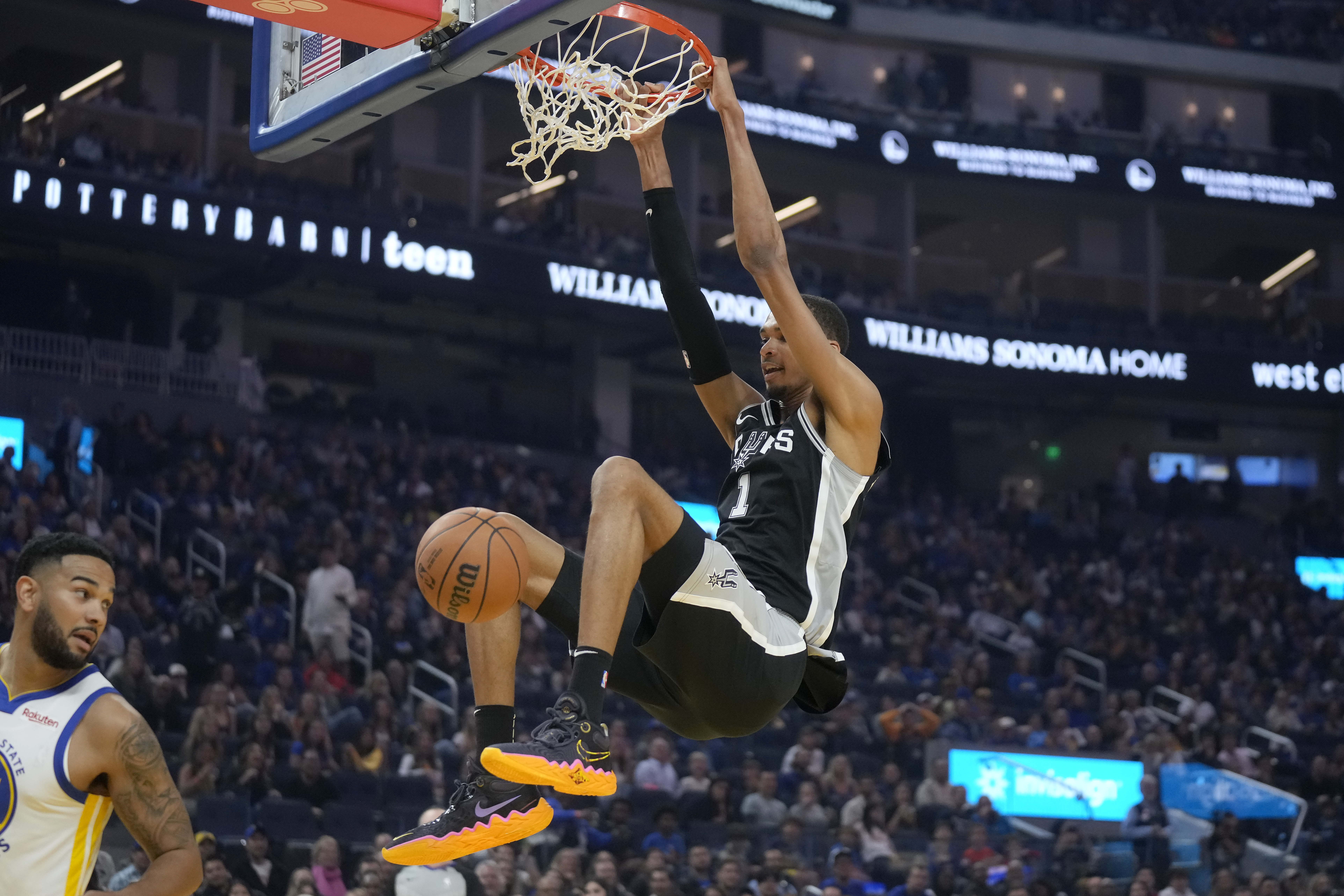 San Antonio Spurs center Victor Wembanyama (1) dunks against the Golden State Warriors during the first half of an NBA preseason basketball game in San Francisco, Friday, Oct. 20, 2023. (AP Photo/Jeff Chiu)