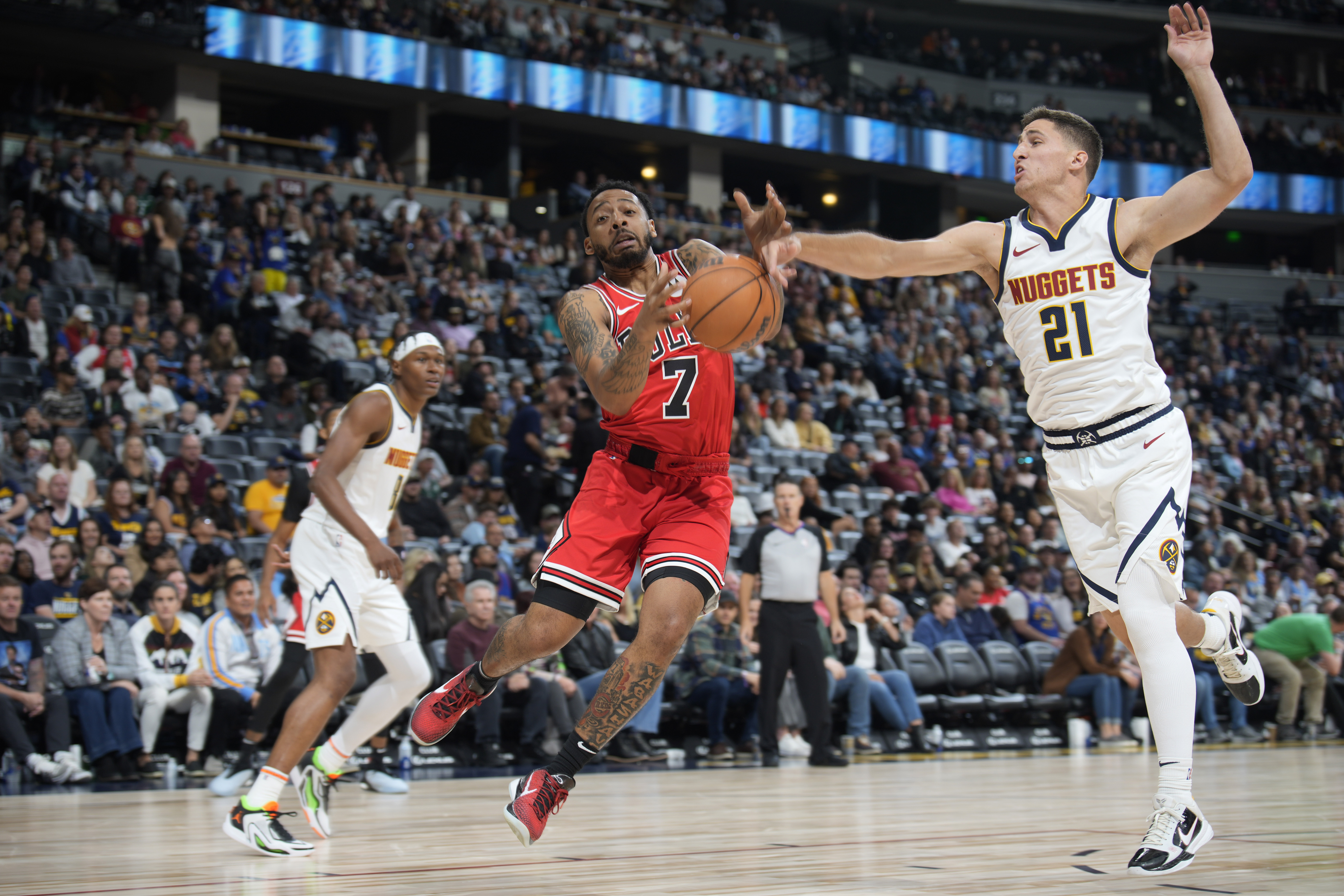 Chicago Bulls guard Carlik Jones (7) loses control of the ball while driving to the rim past Denver Nuggets guard Collin Gillespie (21) in the second half of a preseason NBA basketball game, Sunday, Oct. 15, 2023, in Denver. (AP Photo/David Zalubowski)