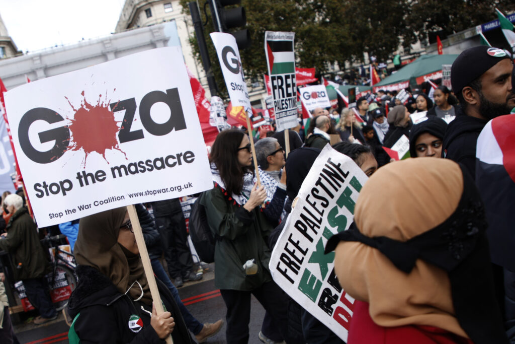 Demonstrators hold up flags and placards during a pro Palestinian demonstration in London, Saturday, Oct. 21, 2023. (AP Photo/David Cliff)