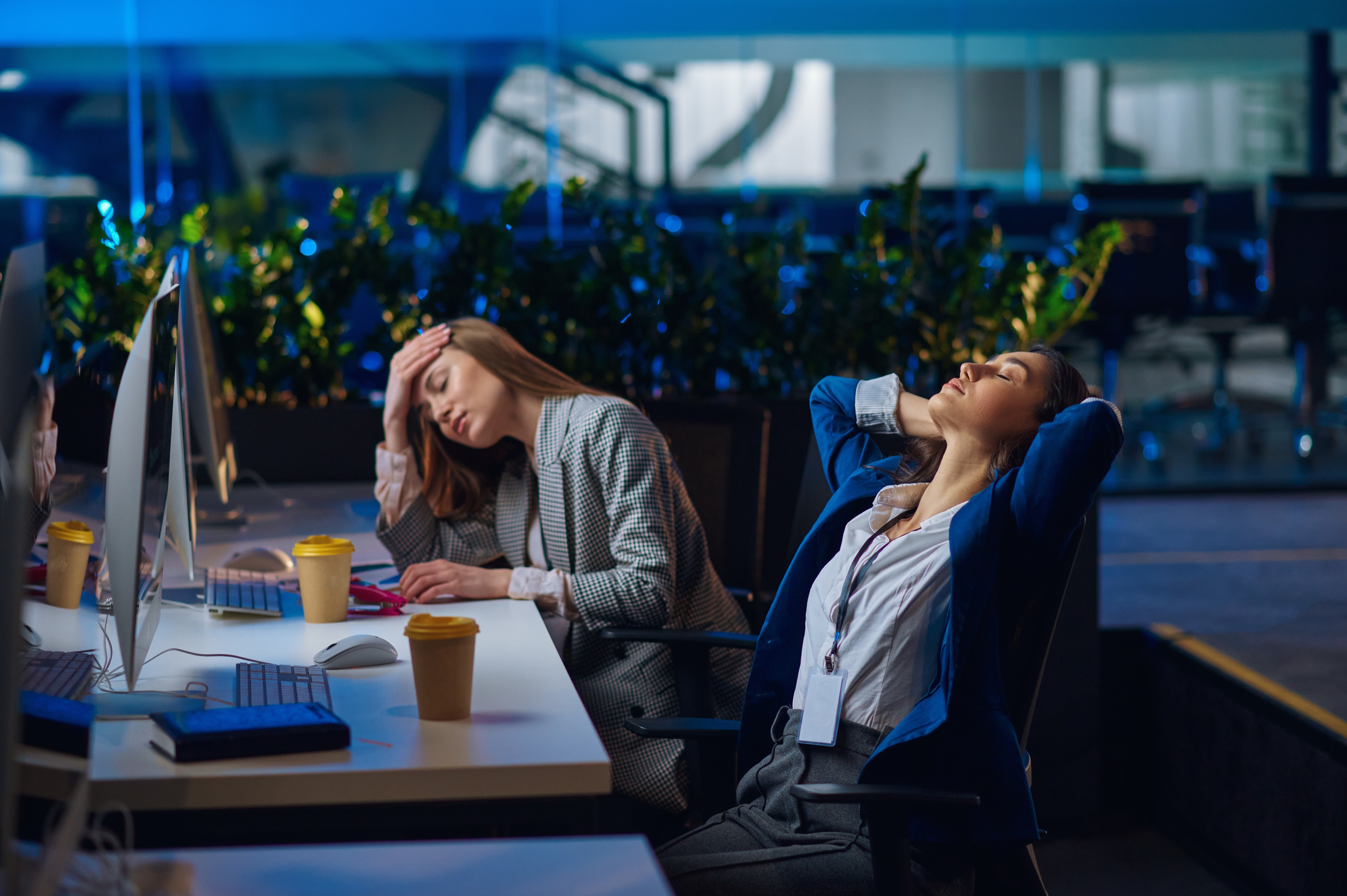 Tired women works on computers in night office