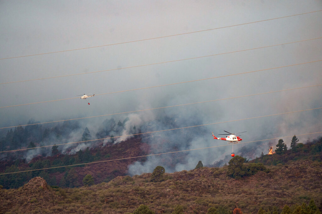 epaselect epa10802409 Firefighting helicopters fly over the area affected by a fire in Candelaria area, Tenerife, Canary Islands, Spain, 16 August 2023.  EPA-EFE/RAMON DE LA ROCHA