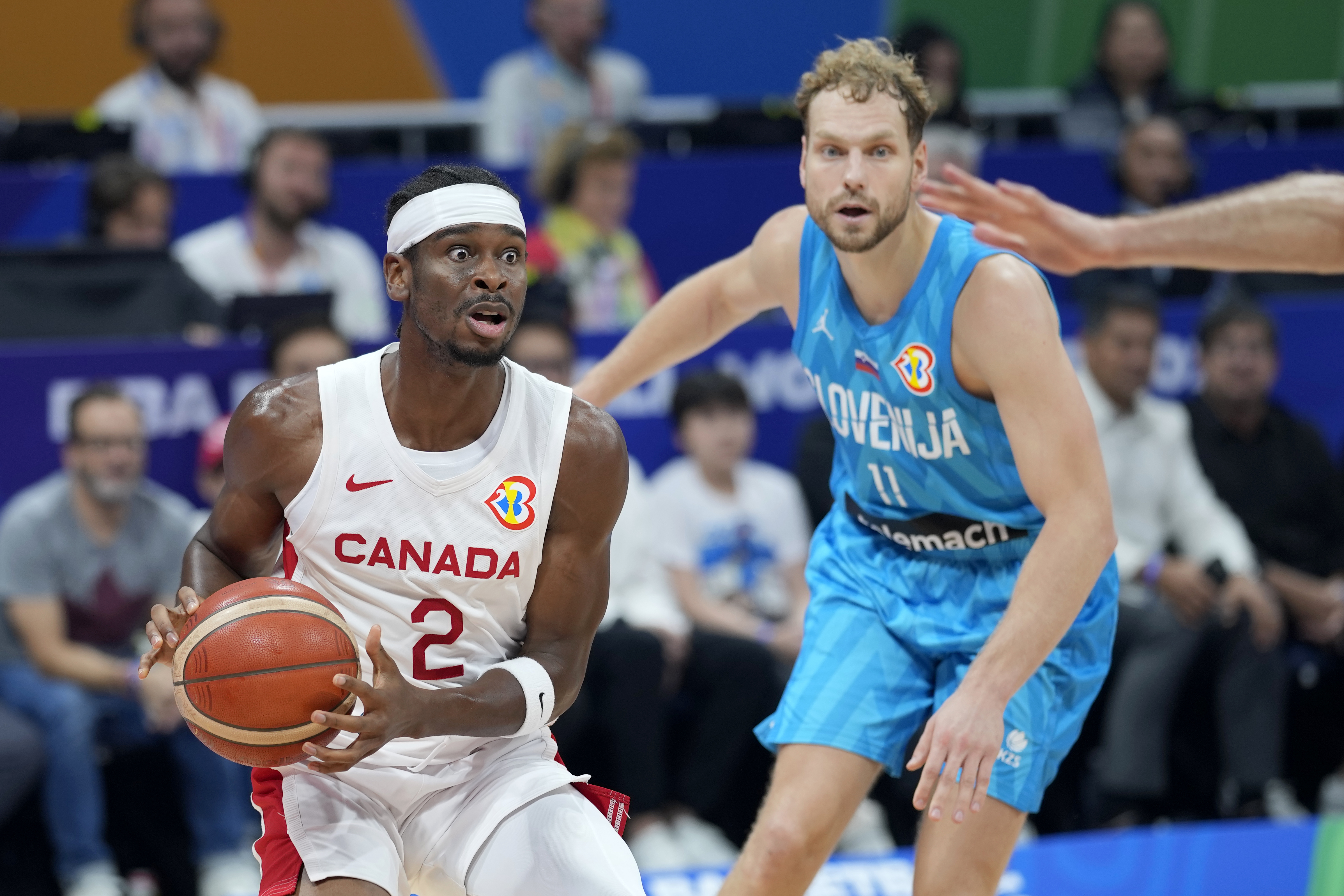 Canada's Shai Gilgeous-Alexander (2) holds the ball as Slovenia's Jaka Blazic (11) defends during the first half of a Basketball World Cup quarterfinal game in Manila, Philippines, Wednesday, Sept. 6, 2023. (AP Photo/Aaron Favila)
