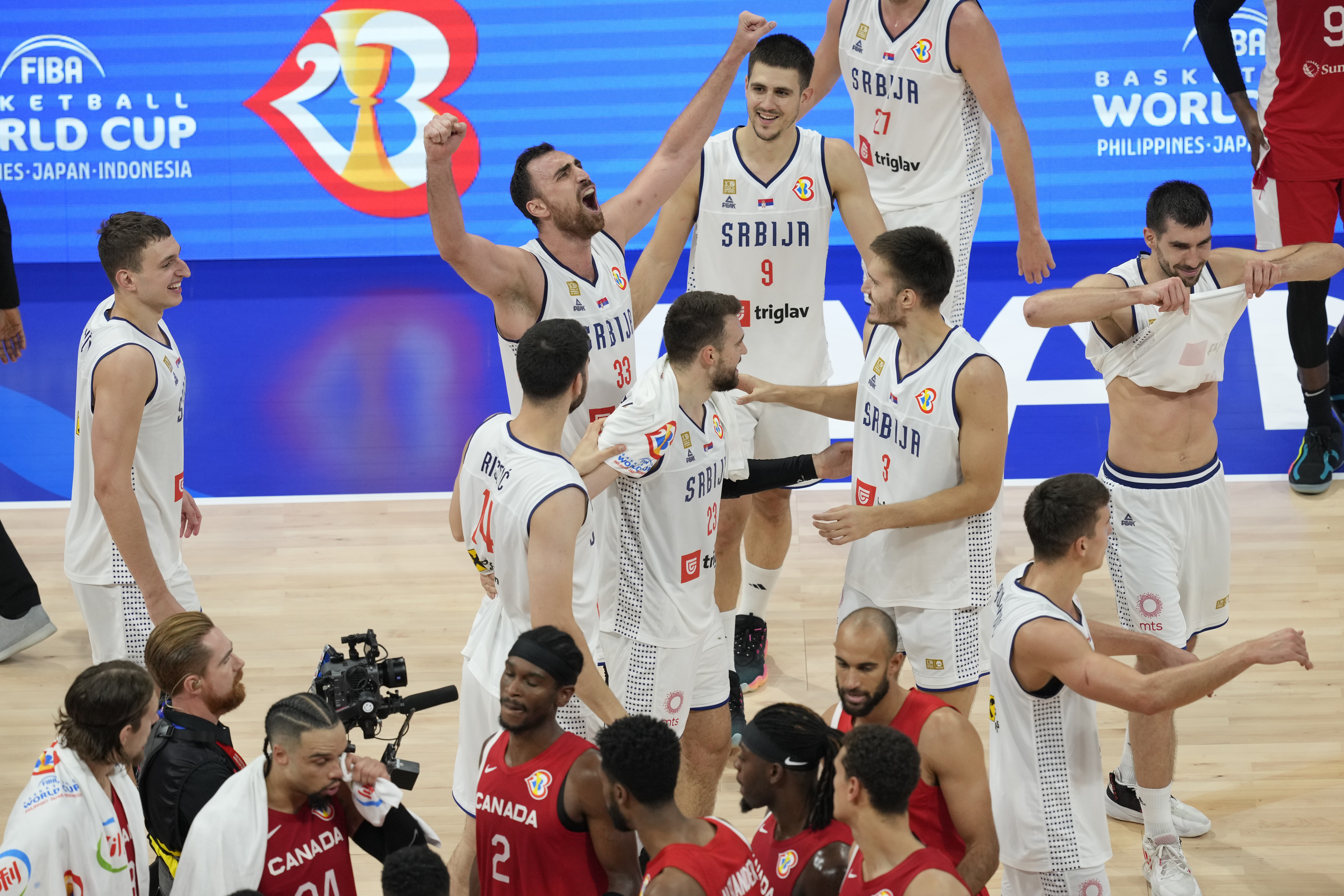 Serbian players celebrate their win over Canada in a Basketball World Cup semi final game in Manila, Philippines, Friday, Sept. 8, 2023. (AP Photo/Aaron Favila)