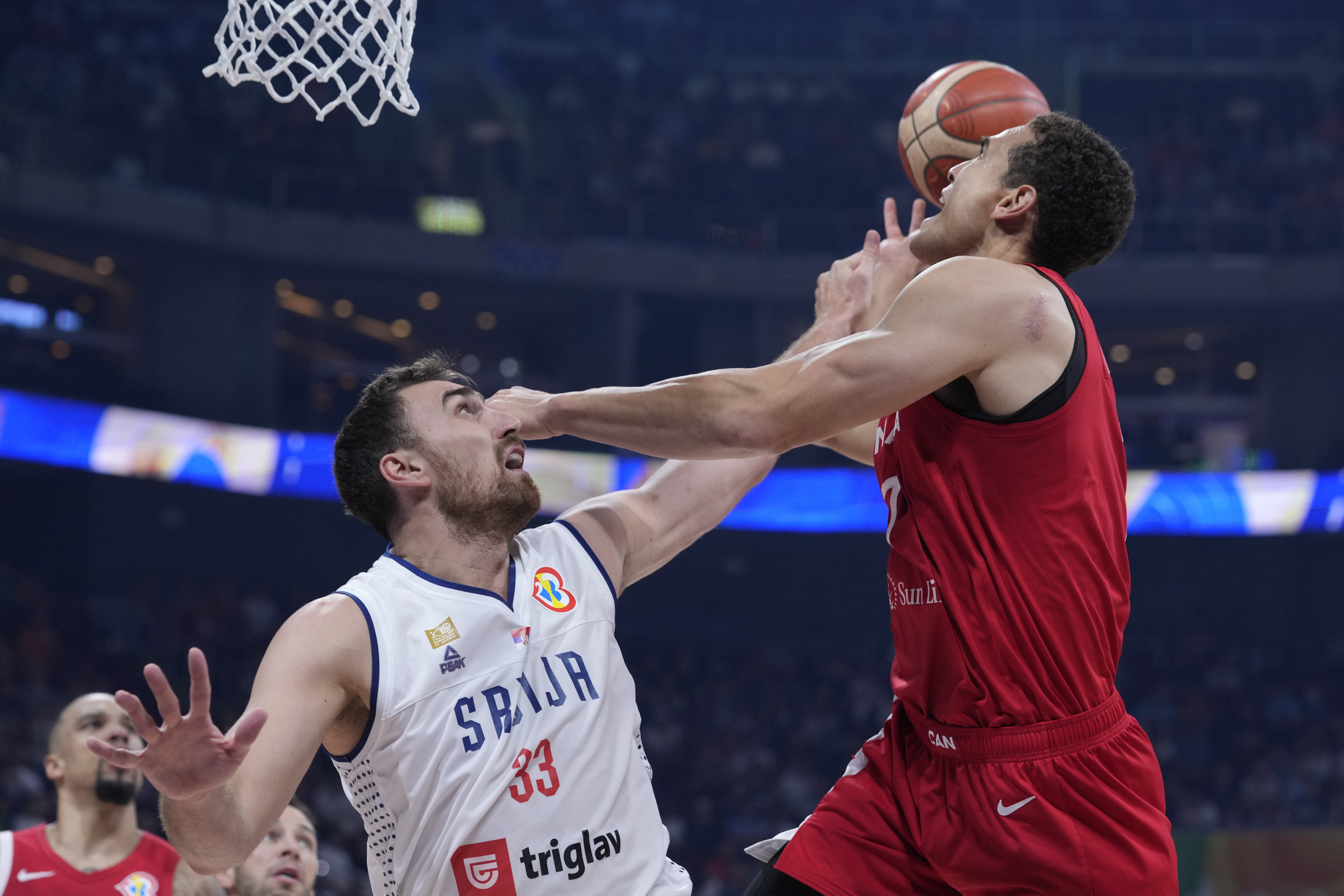 Canada forward Dwight Powell, right is fouled by Serbia center Nikola Milutinov during a Basketball World Cup semi final game in Manila, Philippines, Friday, Sept. 8, 2023. (AP Photo/Michael Conroy)